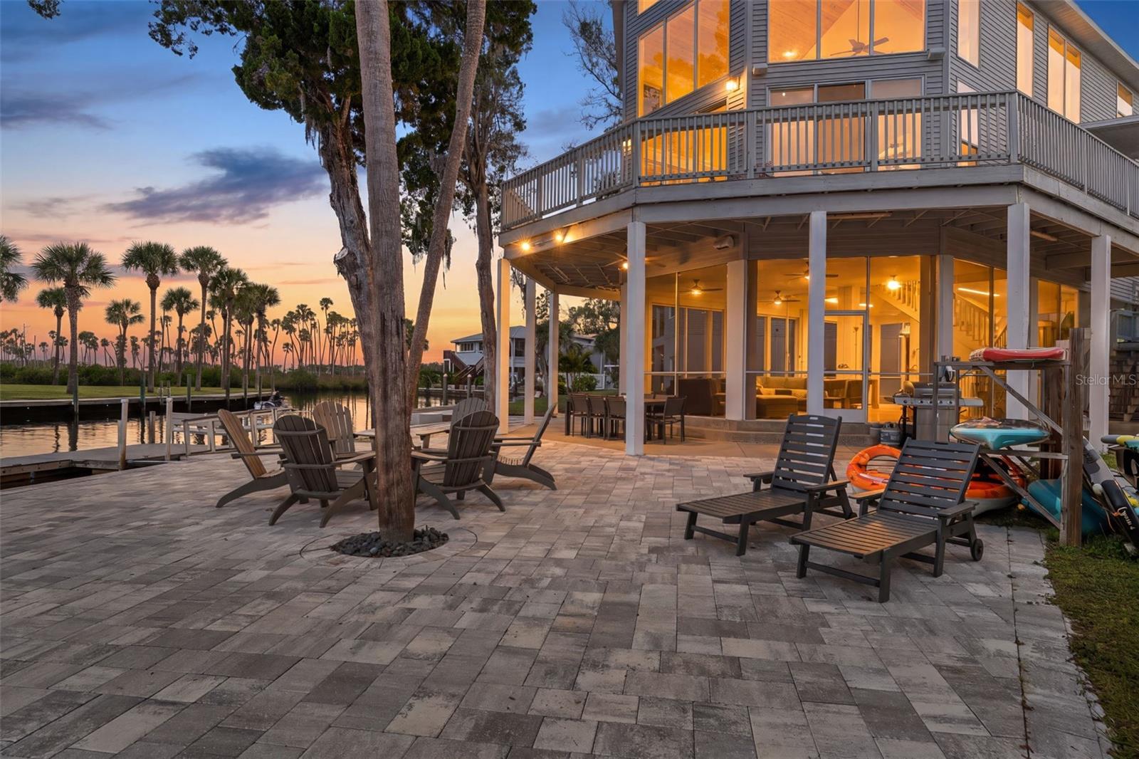 BEST DEAL ON THE RIVER so if you’ve been dreaming of owning a SUCCESSFUL SHORT-TERM RENTAL that OFFSETS the COSTS of the home OR a PERSONAL PARADISE or both, welcome to 5272 Tropical Point. Consistently BOOKED with new and repeat customers, this home provides the best of both worlds: INVESTMENT and/or private use. Even better, everything conveys except the ice machine and Sonos stereo system. This includes furniture, décor, kayaks, fire pit, and outdoor furniture, pool table, and much more, making this property completely move-in ready.

Tucked near the quiet end of the beautiful, spring-fed Weeki Wachee River, this elevated home sits high and dry—remaining completely untouched during the 2024 floods and offering peace of mind year-round. With three bedrooms, two baths, about 1,900 square feet of living area and 3,200 square feet under roof, it perfectly combines comfort, practicality, and that laid-back Florida lifestyle everyone loves. 

The lower level is designed for entertainment and convenience. The huge screened lanai, completed in 2024 with a durable acrylic floor, serves as a spacious entertainment area and currently features a pool table—perfect for gatherings, games, or simply enjoying the breeze off the river in a bug-free setting. You can also enter the lanai directly from the carport, keeping you dry when unloading on rainy days. From inside the lanai, an interior staircase leads straight to the main living area, providing easy, weather-protected access to the upper levels.

From the exterior, a poly-wood staircase leads up to the main level’s wraparound deck, where you can take in stunning river, marsh, and sunset views. Step inside to a bright and open living area with 36-foot tongue-and-groove pine ceilings and a wall of windows that span both upper levels, flooding the home with natural light and capturing breathtaking river views from nearly every angle. The fireplace adds a cozy touch, while the kitchen—with granite countertops and a gas stove—is ideal for cooking and entertaining. The primary bedroom on this level opens directly onto the deck through double doors, creating the perfect spot for morning coffee or evening relaxation. The adjoining bath features a flexible layout with a separate shower and sink area, making it convenient for both owners and guests.

Upstairs, two generous bedrooms and a full bath provide a comfortable retreat for family or visitors. The upstairs landing overlooks the two-story open living area below, giving the home an airy, connected feel while highlighting the dramatic pine ceilings and expansive river views framed by those stunning windows.

Outdoors, this property is built for true Florida living. The full seawall runs the length of the lot and leads to a large dock with a ladder for easy water access—perfect for swimming, kayaking, or boating. The dock can accommodate multiple boats, and the storage shed provides extra space for gear and equipment. A fire pit and updated pavers create the perfect setting for gathering under the stars after a day on the water.

With a newer roof (2021), HVAC (2018), fresh interior paint, updated pavers, fans, and other thoughtful touches, this home blends modern updates with effortless riverfront charm. 

Whether you’re looking for a full-time waterfront home, a weekend escape, or a property with income potential, 5272 Tropical Point offers it all!