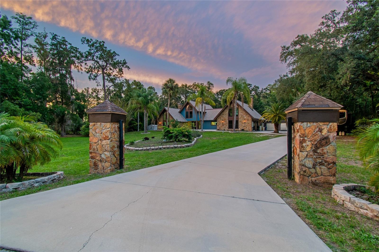 Virtually Staged. Tucked away on a quiet cul-de-sac and set on 1.46 acres of natural beauty, this fully renovated estate offers a rare combination of privacy, space, and refined Florida living.

Featuring 5 bedrooms, 4.5 baths, a 4-car garage, two primary suites, and a fully equipped in-law suite with a private entry, living room, kitchen, bedroom, and full bath, this home is ideal for multi-generational living or extended guest stays. Soaring cathedral and beam ceilings, abundant natural light, and two wood-burning fireplaces create a warm yet impressive interior.

The renovated kitchen showcases quartz countertops and shaker cabinetry, blending timeless style with everyday function. A huge designated interior laundry room with an oversized walk-in closet adds exceptional convenience and storage, while a commercial-grade on-demand water heater provides outstanding efficiency and virtually endless hot water.

Outdoor living is exceptional with approximately 3,000 sq. ft. of screened space, a resort-style pool, covered entertaining areas, and a fire pit—perfect for year-round enjoyment.

Set beside a peaceful bird sanctuary, the property offers daily privacy and natural views while remaining minutes from shopping, dining, and major conveniences. Located within highly rated, A-rated Trinity-area schools, this home offers access to some of the most sought-after educational opportunities in Pasco County.

Extensive updates include luxury vinyl plank flooring throughout, remodeled bathrooms, quartz countertops, shaker cabinetry, newer hurricane-impact windows and doors, newer roof and siding, commercial-grade pool equipment, RV parking with a 50-amp hookup, and numerous improvements designed for comfort, durability, and peace of mind.

With no HOA and no deed restrictions, this estate delivers freedom, flexibility, and a true Florida lifestyle.

Private acreage. Luxury living. Exceptional opportunity.