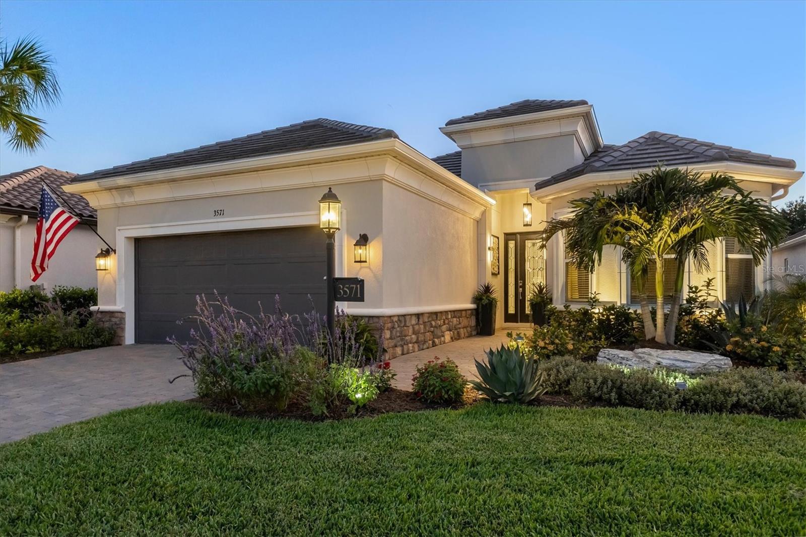 Over $125,000 in Post-Closing Improvements Not Included in Current Builder Models! Experience resort-style living every day in this beautifully appointed Lazio model in Esplanade at Azario — where luxury, wellness, and recreation come together in one exceptional community. One of Taylor Morrison’s most sought-after floor plans, this residence offers 2,380 square feet of thoughtfully designed living space with 3 bedrooms, 3 full baths, a private study, and a spacious three-car tandem garage. From the moment you enter through the grand foyer with soaring ceilings, you’ll appreciate the home’s elegant finishes and open-concept design. Neutral tile flooring, bright interior paint, crown moldings, tray ceilings, 8’ doors, upgraded lighting fixtures, custom wainscoting, designer wallpaper, and stylish window treatments create a sophisticated yet inviting atmosphere throughout. The cozy great room with Dimplex linear electric fireplace flows seamlessly into the designer kitchen. The kitchen features stylish two-tone cabinetry, quartz countertops, large center island with prep sink and additional storage, stainless steel GE Cafe appliances, and a generous pantry, making it ideal for entertaining and everyday living. Sliding glass doors open to the extended lanai, creating the perfect indoor-outdoor lifestyle Florida is known for. The extended lanai’s outdoor living space is truly exceptional, complete with leathered marble pavers, in-cage lighting, Storm Smart hurricane shades, and pre-plumbing for an outdoor kitchen. Relax in the custom heated pool featuring a sun-shelf, three tranquil water features, and an autofill system while enjoying the beautifully landscaped surroundings with additional landscape lighting. The private primary suite overlooks the pool and offers a luxurious retreat with dual sinks, a large walk-in shower with dual shower-heads, a water closet, recessed mirrored medicine cabinets, and a spacious walk-in closet. Two additional guest bedrooms, each with access to their own designated bathrooms, are thoughtfully positioned on the opposite side of the home for added privacy. The tandem 3-car garage offers additional ceiling storage racks and room for your golf cart. Additional upgrades include a whole-house Generac generator, water softener, full-house surge protector, alarm system, automated doorbell and garage systems, built-in speakers in the main living area and lanai, upgraded 10-foot ceilings throughout, and custom landscaping surrounding the home. Living in Esplanade at Azario means enjoying an unmatched lifestyle with resort-style amenities, concierge services, wellness programs, and a vibrant social atmosphere. Residents enjoy their choice of 5 restaurants, a spectacular resort pool with the Bahama Bar, a luxurious wellness center offering massage therapy, skincare, manicures, pedicures, fitness programs, and aquatic classes, as well as an 18-hole championship golf course with public tee times and pro shop. The newly opened 15,000-square-foot Culinary Center provides world-class dining and culinary experiences, all within one of the area’s most desirable communities and conveniently located near highly rated Manatee County School District schools.