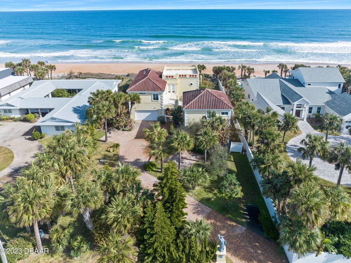 Fabulous oceanfront home constructed on north east Florida's premier stretch of Atlantic Shoreline with fantastic views from a lofty perch on this unusually tall dune line. Custom built in 2000, the main home offers 3 of the 4 bedrooms and a marvelous open living room designed for constant views of the beach and the horizon beyond. The 1 bedroom private guest quarters with vivid views of the ocean is accessed by a catwalk from the main residence offering guests the ultimate in privacy and independence. The tiered oceanfront lawn opens directly onto a particularly quiet section of the beach. Pull into the paver appointment courtyard drive and choose from double two car garages before entering the gated, covered verandah that gives way to the double door entryway. CONTINUED...

Step inside to be immediately greeted by the Atlantic Ocean as the easterly side of the vast great room is comprised of a large bank of generous glass panels inviting the ever changing seascape indoors. This vast oceanfront great room was designed to entertain a crowd within one waterfront space or allow the owners' large extended family to relax in separate dedicated, intimate seating, dining and lounging areas without compromising the warmth of the presence of family. Whether sitting in front of the fireplace in the oceanfront conversation lounge or relaxing a few steps above in the generous living room with it's gallery walls or taking in a game off chess in the family room, the views are simply mesmerizing. The large island kitchen was built as an extension of the living space with a splendid oceanfront casual dining area and wonderful natural light pouring in from a plethora of windows and glass doors that overlook the oceanfront lawn and surrounding courtyard gardens. The second story is gone to three generous oveanfront suites including the gracious master suite with cavernous closets, a massive home office space, and luxury bath with an ocean view garden tub and steam room. All three suites feature private baths and open onto a magnificent terrace that spans the entire length of the main home. A second rooftop terrace is accessed by a ladder stairway that leads to top of the second story for private sunbathing in the day or the ultimate platform to stargaze in the evening. The second garage is an oversized two car garage with extra space for beach toys and motorcycles. This section of the estate is attached to the main h ome through a covers breezeway that stretches across the gated courtyard with an outdoor staircase that leads to the very complete private guest home. Just 72 residential estate lots exist in this highly desirable area just north of Granada Blvd within the city limits of Ormond Beach. The owners of these properties enjoy a quiet beach atmosphere where vehicle traffic is prohibited and foot traffic is quiet low due to a lack of public parking that limits typical beach access to a few early bird visitors who are fortunate enough to find parking or neighboring residents out for a routine stroll. This particular property sits approx 500 ft from the closest walkway access point which crates a predictably serene atmosphere even on the busiest holiday weekends. The 4507 sq ft home and guest home was constructed by highly regarded contractor Steve Thompson of Centurion Builders and is in need of nothing.
Priced to sell!