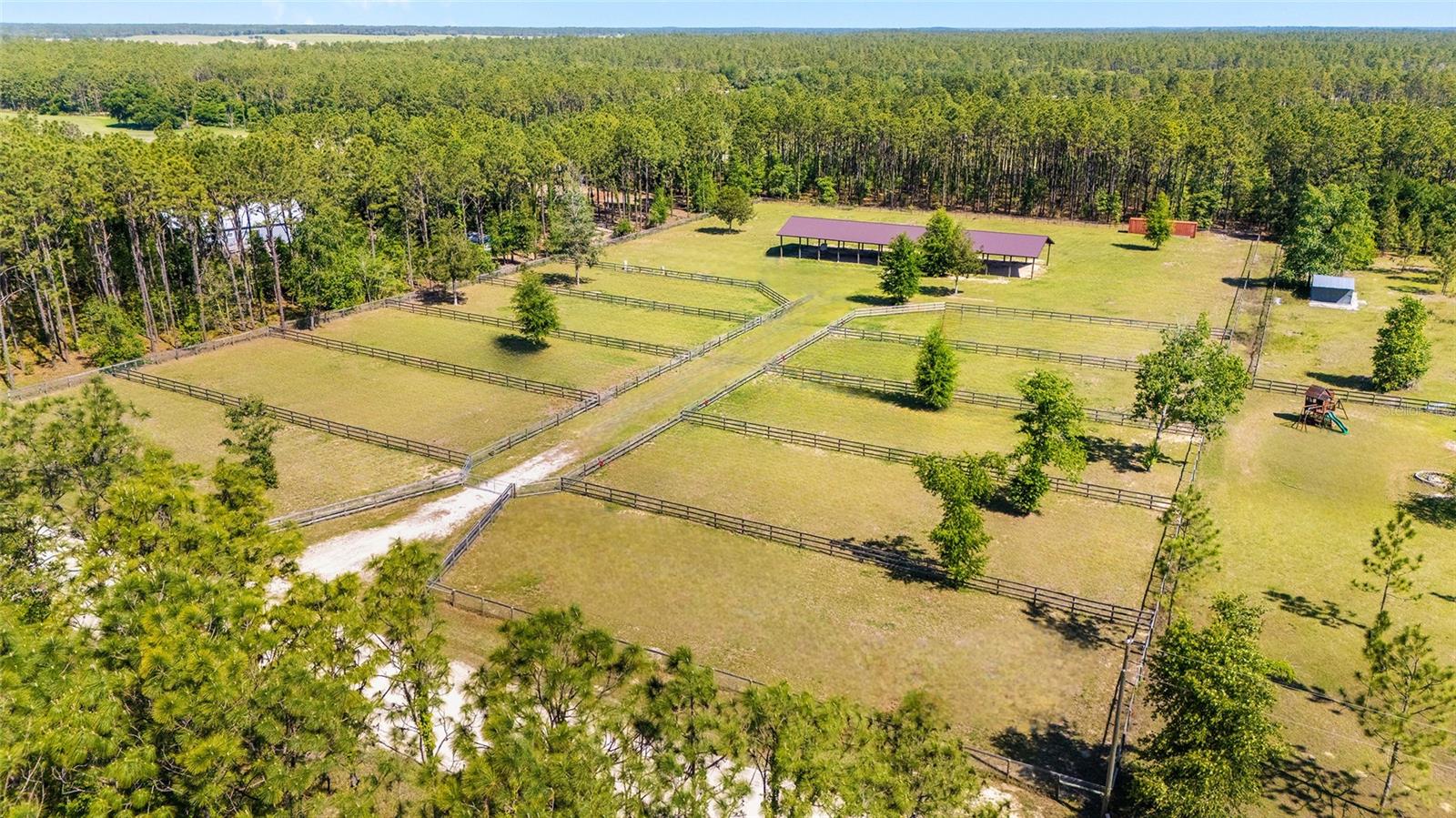 Welcome to this beautifully laid-out 5-acre equestrian-ready property in the heart of Morriston, Florida—perfectly positioned for those looking to build their dream farm or establish a functional horse setup from day one. With no HOA and no deed restrictions, and impact fees already paid, this property offers both flexibility and value in one of Levy County’s most desirable areas.

As you enter through the wide culvert entrance and follow the drive, you’ll immediately notice how well-designed and usable this property is. The entire acreage is fully fenced with no-climb wire and top rail, providing safety and peace of mind for your animals.

The centerpiece of the property is the impressive 40x144 barn, built with 12-foot centers and eaves, offering an incredible amount of space for equipment, hay storage, stalls, or future customization. Whether you’re a trainer, hobbyist, or seasonal rider, this structure gives you a strong foundation to build out exactly what you need.

The land is thoughtfully divided into 10 paddocks, each measuring approximately 64x164, enclosed with sturdy three-board fencing and equipped with 12-foot field gates for easy access and efficient management. A new well with a 3-horsepower motor is already in place, along with power to operate it, ensuring a reliable water source for your farm.

This property is truly a blank canvas with the infrastructure already started—ready for you to add a home, expand the barn, or tailor it to your specific equestrian discipline.

Located just 13 miles to the World Equestrian Center, 10 miles to HITS Showgrounds, approximately 25 miles to Crystal River for boating and water activities, and a short drive to the Goethe State Forest for trail riding, this location offers the perfect balance of convenience and country living.

If you’ve been searching for a manageable, well-equipped piece of land in prime horse country, this property is ready to bring your vision to life.