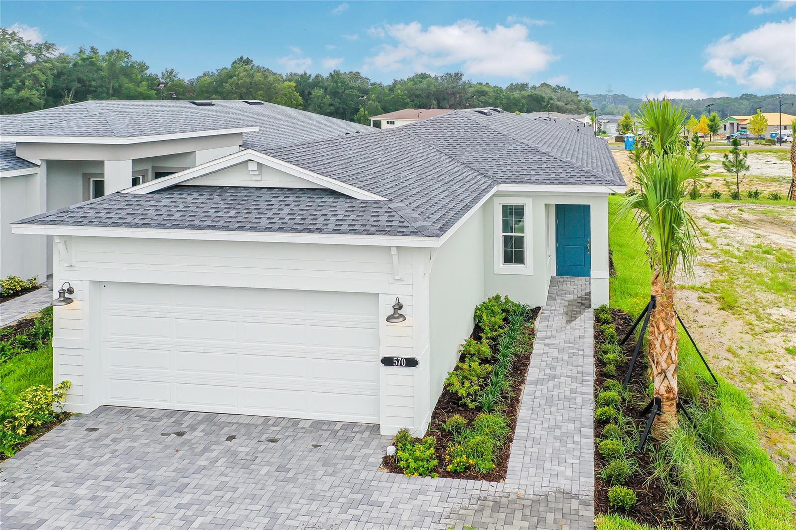 MOVE-IN READY. Cresswind at Hammock Oaks, a new active 55+ community by Kolter Homes, is situated in Lady Lake, FL, famously known as the “home of lakes and sunshine.” Located near The Villages the community is only minutes from Leesburg and convenient to Orlando. This gated community in Central Florida features Cresswind's national award-winning "Set Yourself FREE" lifestyle program based on the cornerstones of Fitness, Relationships, Education and Entertainment. The resident-only clubhouse with a state-of-the-art fitness center and offers 55+ neighbors a place to gather and participate in social activities facilitated by a full-time Lifestyle Director. Outdoor amenities will include pickleball & tennis courts, walking trails, resort-style pool and spa, pool, event and entertainment areas. Introducing the Ana Floor Plan, a beautifully crafted new construction home designed to fit a wide range of lifestyles. Located in a secure, gated community, this modern 2-bedroom, 2-bath residence includes a flexible Flex Room and a spacious attached 2-car garage—making it an ideal choice for buyers seeking comfort, security, and contemporary design in a thriving neighborhood. As you arrive, the inviting front porch offers charming curb appeal and a tranquil space to welcome guests or relax outdoors. Step inside to experience an open-concept design, where luxury vinyl plank flooring flows seamlessly throughout the main living areas, providing both durability and on-trend style. The centerpiece of this home is the chef-inspired kitchen, outfitted with frameless European-style cabinets, a deep cabinet above the refrigerator, expanded pot and pan drawer storage, and upgraded large cabinet crown molding. Home chefs will love the upgraded slide-in natural gas range, luxury 3cm quartz countertops, and artisan tile backsplash, creating the perfect environment for meal preparation and entertaining. The large kitchen island connects effortlessly to the Great Room, fostering a sense of unity and allowing for easy gatherings with friends and family. The thoughtfully designed split-bedroom layout ensures privacy for both the owner’s suite and the secondary bedroom, making this floor plan perfect for families, couples, or those who frequently host guests. The owner’s suite is a peaceful retreat, featuring an expansive closet and a luxurious bathroom with a frameless shower enclosure, upgraded pebble tile shower floor, and brushed nickel plumbing fixtures. Tile-to-ceiling showers and high-quality materials in both bathrooms add an extra touch of sophistication and comfort. The versatile Flex Room offers endless possibilities, easily transforming into a home office, formal dining area, fitness studio, or additional guest room to meet your changing needs. Laminate wood plank flooring continues into the Flex Room and owner’s suite, while upgraded carpet in Bedroom 2 ensures comfort underfoot. Outdoor living is an extension of the home with a covered lanai that’s perfect for year-round enjoyment—whether you’re hosting alfresco dinners, relaxing with a book, or grilling with the dedicated natural gas line. Energy-efficient features such as the exterior tankless water heater provide continuous hot water and cost savings. The attached 2-car garage ensures secure parking and ample storage for vehicles, tools, or recreational equipment.