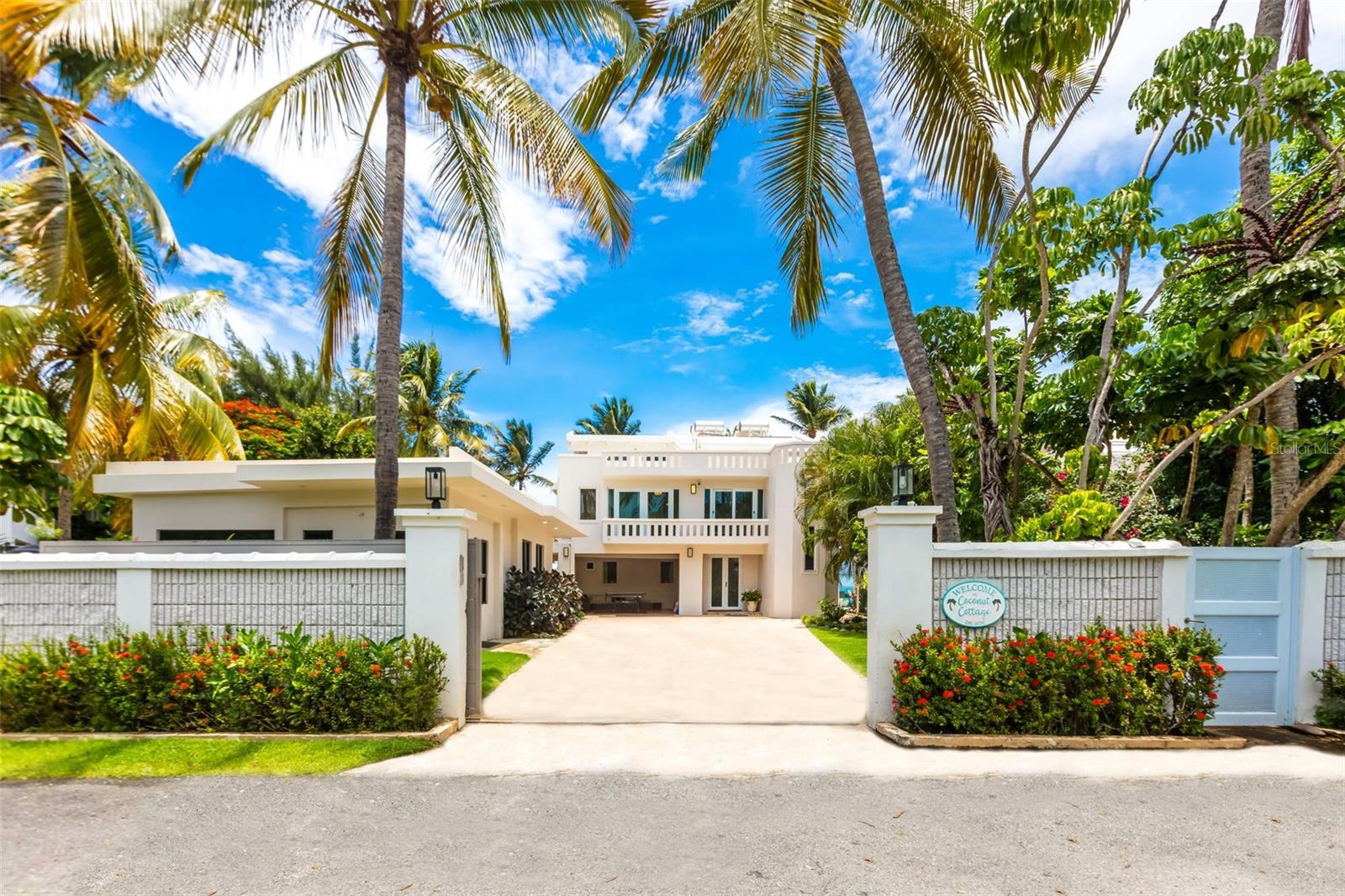 Paradise found in this oceanfront sanctuary, where contemporary elegance meets Caribbean charm. This 4,316 Sq. Ft. villa, set on a 1,017 Sq. Mt. lot, offers 8 bedrooms and 6.5 bathrooms, designed for those appreciate the essence of coastal living.

The main house: 
The first-floor features 2 bedrooms, living and dining area with a kitchenette, and a full bathroom. The living room opens directly to the patio and pool, offering easy access to the beach via a staircase. The second floor features 2 bedrooms, each with their private balconies, 2 full bathrooms, a fully equipped kitchen, and a bright living room with a balcony showcasing panoramic ocean views. The third floor provides a tranquil retreat with a bedroom, living room, full bathroom, and a large roof deck with a staircase from the oceanside balcony that descends to the beach, inviting you to relax in the turquoise waters or embark on a kayaking or paddleboarding adventure.
The property includes a separate guest house with 3 bedrooms, 2 full bathrooms, and two private entrances—one serving the 2-bedroom and the other for the 1-bedroom. This setup provides flexibility for extended family stays or rental opportunities, including its current use for Airbnb.

The property's design offers the option for private use or (4) four independent rentals, presenting an exceptional investment opportunity for both short-term and long-term stays.

This compound features a well-appointed outdoor kitchen, perfect for entertaining by the pool and jacuzzi. It also offers three covered terraces, carport, a 20 KW power generator, and a 500-gallon water cistern.

Located in the vibrant Río Grande area, this coastal haven is just 35-40 minutes from San Juan Airport. It’s a short drive from the renowned Río Mar Wyndham Resort, which offers a championship golf course and stunning beach. Nearby, the Kioskos de Luquillo provide a taste of exquisite local cuisine, while the El Yunque National Forest offers adventures amidst lush rainforests. Boating enthusiasts will appreciate the proximity to marinas, and attractions in Luquillo, Fajardo, Carolina, and San Juan are easily accessible.