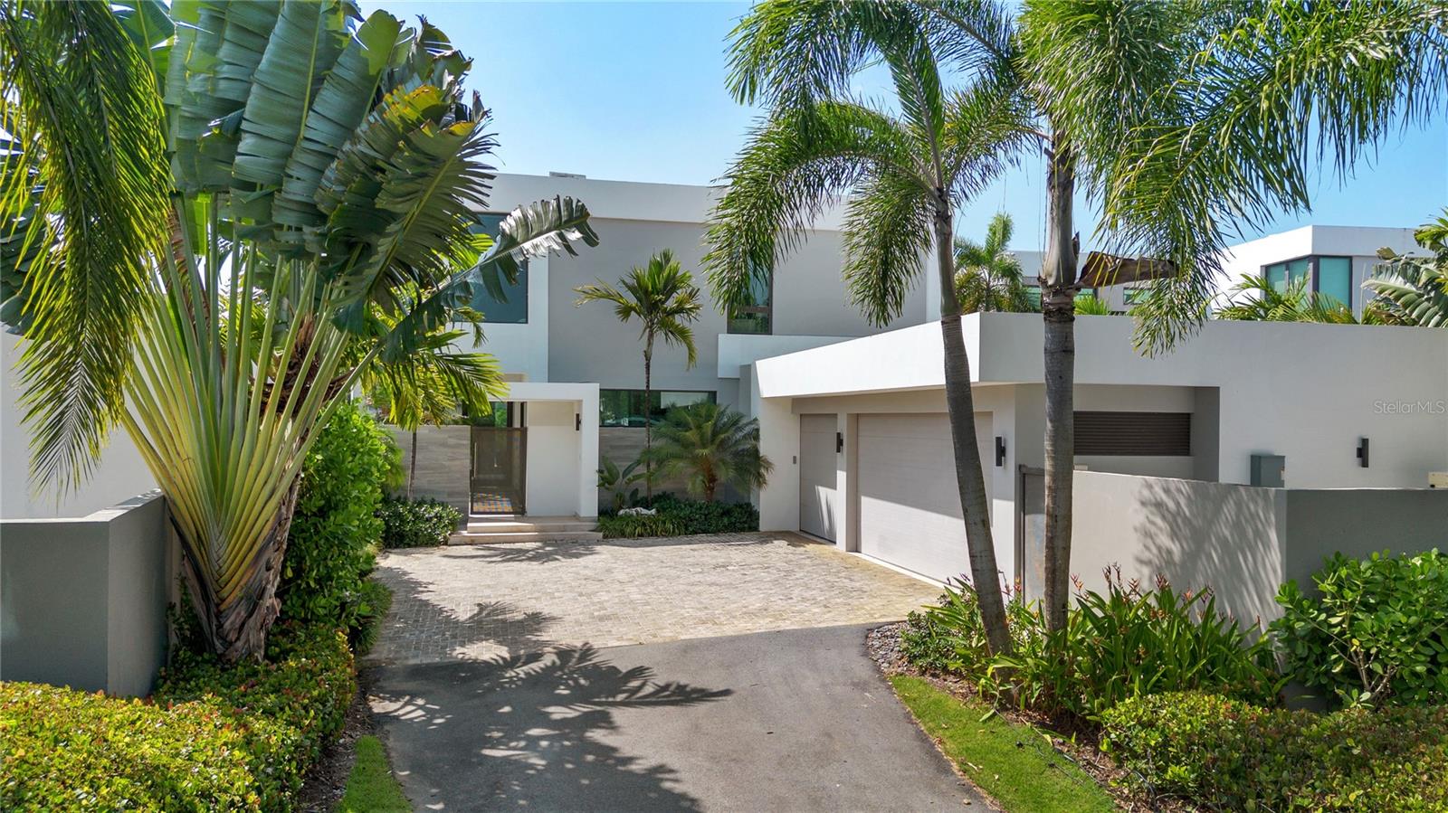 Welcome to The Enclave, an exclusive neighborhood within Dorado Beach Resort featuring just 28 residences arranged in a private cul-de-sac setting with landscaped green space and convenient guest parking directly in front of the property. This modern two-story home spans approximately 5,954 square feet of gross construction on a 931 square meter lot, thoughtfully designed with five bedrooms, five and one half bathrooms, and two versatile living areas. The main level features a built-in mudroom off the garage, a versatile room perfect for a gym, classroom, or game room, and a full guest suite. The open kitchen connects seamlessly to the living and formal dining areas, opening to a covered terrace, pool, and outdoor kitchen for effortless indoor-to-outdoor living with beautiful views of the golf driving range. Upstairs, three additional bedrooms are complemented by a spacious office filled with natural light, creating an ideal work-from-home setting. The primary suite features a private terrace overlooking the greens, offering a serene sense of privacy and resort living. Located within one of Dorado’s most desirable residential communities, this residence offers exceptional access to wellness, recreation, and community, all just a golf cart ride from the beach and the world-class amenities of Dorado Beach Resort.