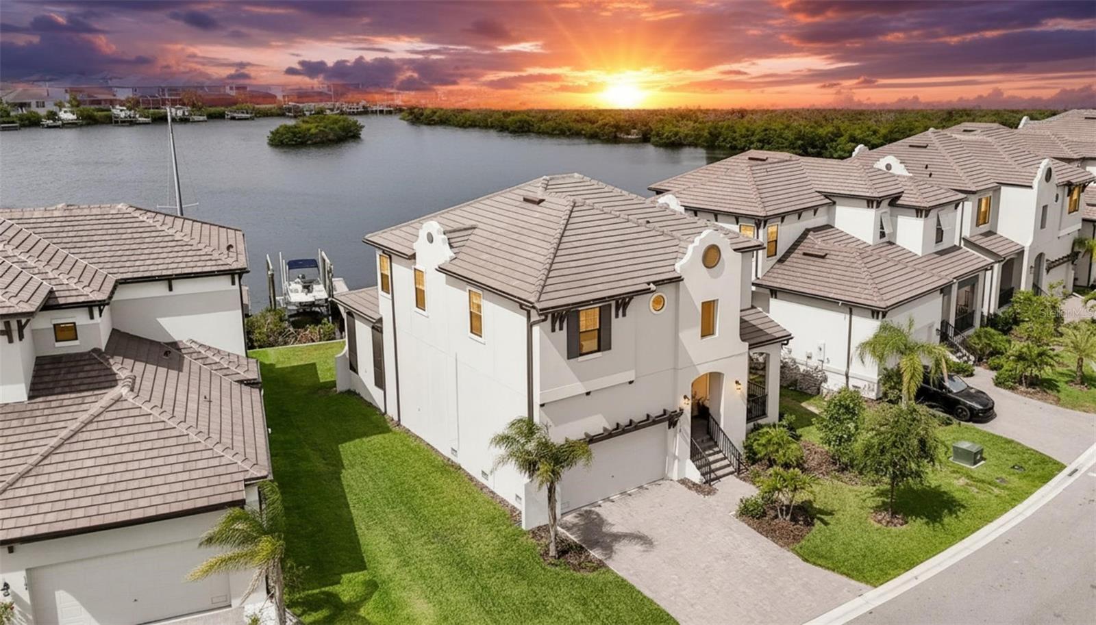 Welcome to waterfront living at its finest in the highly sought-after Southshore Yacht Club at Little Harbor! This stunning Biscayne II residence offers 2,403 sq ft featuring 3 bedrooms, 2.5 baths, a private office, spacious loft, and 2-car garage. Perfectly positioned on a premier homesite, this property showcases a rare big-water view of a saltwater lagoon, offering panoramic open water vistas and privacy rarely found in Tampa Bay waterfront communities. For boating enthusiasts, this home is turnkey with a brand-new private dock and 13,000-lb boat lift. Enjoy direct deep-water, no-bridge access to Tampa Bay and the Gulf of Mexico, accommodating center consoles, cruisers, and sailboats. Your boat is always steps away for fishing, dining, island hopping, or sunset cruises. A standout feature is the oversized backyard with ample room for a custom resort-style pool—something rarely available on comparable waterfront lots. Pool plans are already completed and available to the buyer for a seamless start to your outdoor oasis. Also, the first-floor office has been significantly enhanced with custom-built cabinetry, shelving, and integrated storage added by the homeowner, creating a highly functional and refined workspace. Outdoor living is enhanced by a screened lanai overlooking the lagoon, ideal for morning coffee, sunsets, and watching dolphins and manatees in the peaceful waterfront setting. Inside, the open-concept layout connects the gourmet kitchen, dining, and great room. The first-floor office features custom built-ins and upgraded cabinetry, creating a refined, functional workspace. Upstairs includes a spacious loft and a luxurious owner’s suite with water views and spa-style bath. Built with elevated coastal resilience in mind, the home includes impact-rated windows and sliding glass doors, along with modern construction standards designed for enhanced storm protection and durability. Residents enjoy resort-style amenities including a waterfront clubhouse, marina, pool, fitness center, pickleball, basketball, trails, private beach access, and waterfront dining. A major advantage is the exceptionally low flood insurance premium of just $887/year, reflecting the home’s newer construction and storm-resilient design features, including impact protection and elevated building standards. This is a rare opportunity to own a nearly new waterfront home with big-water lagoon views, deep-water no-bridge access, new dock and 13,000-lb lift, custom office, pool-ready yard, and premier coastal lifestyle—all in one of the area’s most desirable communities.