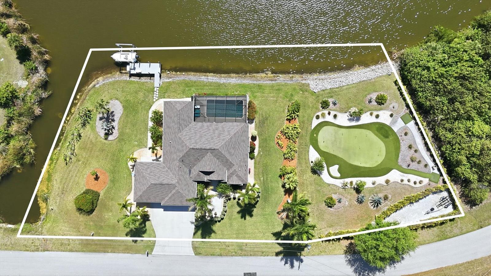Look no further, your waterfront estate with 230 feet of shoreline and a private putting green awaits. Perfectly positioned on a rare TRIPLE LOT along one of the widest sections of the Santa Cruz Waterway, this exceptional residence delivers an elevated Florida lifestyle defined by space, privacy, and refined outdoor living. Offering 2,109 square feet, this 3-bedroom, 2-bath home is being offered FURNISHED, allowing for an effortless, move-in-ready experience. From the moment you arrive, the expansive grounds and lush, manicured landscaping create a striking first impression. Inside, the home blends comfort and sophistication with a thoughtfully designed layout ideal for both everyday living and entertaining. The completely updated kitchen serves as a stunning focal point, featuring beautiful quartz countertops, new cabinetry, and a clean, modern aesthetic that elevates the entire space. The primary suite is a true retreat, complete with dual closets and sliding glass doors that open seamlessly to the outdoor living area, perfectly capturing the essence of indoor-outdoor coastal living. Step outside and experience what truly sets this property apart. Your private waterfront oasis showcases a heated pool with a newer heater (2021) and a newly re-screened lanai (2023), all overlooking 260 feet of breathtaking waterfront. A private dock and boat lift provide direct access to open water, creating an exceptional setting for boating enthusiasts. The additional lot further enhances this one-of-a-kind property, featuring your very own beautifully maintained putting green, surrounded by lush tropical landscaping, offering a true resort-style experience right at home. Recent updates include a new roof (2023), adding peace of mind and long-term value. Additional features include irrigation for effortless lawn care and an insulated garage with a dedicated workshop space. Located in the highly sought-after waterfront community of South Gulf Cove, offering over 55 miles of navigable canals, this property is ideally situated between Sarasota and Fort Myers and just minutes from world-class fishing, championship golf, pristine Gulf beaches, dining, and shopping. This is more than a home, it is a rare waterfront offering defined by unmatched frontage, curated outdoor living, and a lifestyle designed to impress. Paradise awaits.