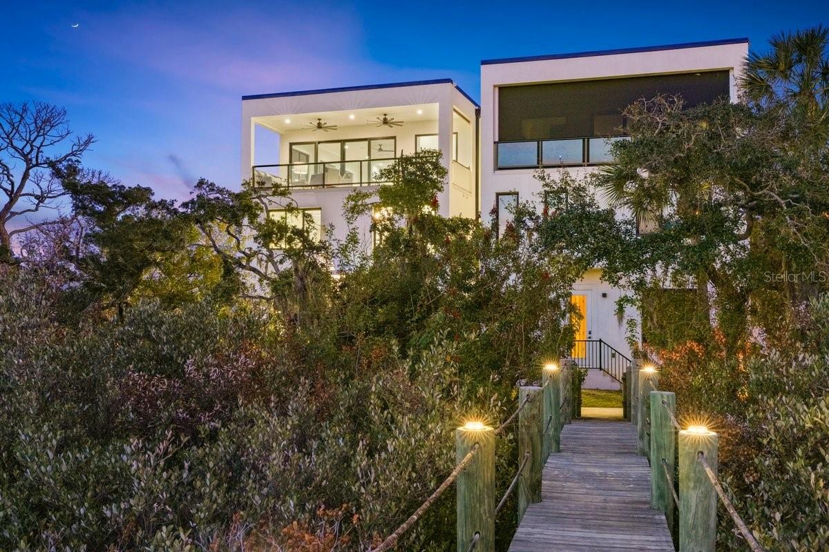 Waterfront living in New Smyrna Beach’s coveted Central Beachside district reaches a new level at 552 N Peninsula Avenue, a newly constructed 2024 modern residence positioned along the deep water Callalisa Canal/Creek with direct access to the Intracoastal Waterway. Designed for the avid boater, this exceptional property offers 3 deep water boat slips, including a 16,000 lb boat lift, allowing effortless access to the Intracoastal, Mosquito Lagoon, Ponce Inlet, waterfront restaurants, and the Atlantic Ocean right from your private dock. Located in the heart of Central Beachside New Smyrna Beach, the home also offers golf cart convenience to the beach, Publix, Flagler Avenue’s shops and restaurants, and nearby Smyrna Dunes Park. Spanning three stories with a private elevator, the residence showcases sleek modern architecture and over 3,700 square feet of coastal living, with panoramic water views from the third floor balcony, main living area, and designer kitchen. The home features 4 spacious bedrooms and 4 1/2 baths, with each bedroom designed as a private retreat complete with its own ensuite bath, offering both comfort and privacy for family and guests. The main living space is filled with natural light and flows seamlessly into a chef inspired modern kitchen, creating an inviting environment for entertaining while enjoying the tranquil waterfront setting. The first floor offers exceptional flexibility, making it ideal for a variety of lifestyles. A private suite on this level can easily function as an in-law suite, guest quarters, or a quiet home office, providing separation and privacy from the main living areas. The oversized laundry and utility room has been thoughtfully designed with boaters and anglers in mind, doubling as a fishing gear and rod storage area and featuring an ice machine, making it easy to prepare for a day on the water or return from an afternoon of fishing. Outdoor living is equally impressive, highlighted by an expansive third floor balcony with a fully equipped summer kitchen, offering the perfect vantage point for coastal breezes and beautiful sunsets over the canal.  Additional luxury features include a two car garage with generous storage, a commercial grade TPO roof with an estimated 15–20 year life expectancy, and an underground filtration system designed to collect and disperse watershed. The property carries a LOMAR designation, meaning flood insurance is not required, and it is located in Flood Zone X. Paver driveway and electric gate from the south of the property provide peace of mind. Perfectly positioned between the Intracoastal Waterway and the Atlantic Ocean, this exceptional residence blends modern design, luxury waterfront living, and the relaxed coastal lifestyle that makes New Smyrna Beach one of Florida’s most sought after destinations. This is more than a home, it is a rare deep water canal estate in one of New Smyrna Beach’s most desirable waterfront corridors. Buyers are encouraged to view the video tour. *****Seller is offering a $20,000 initiation application fee to the  Smyrna Yacht Club membership. ******