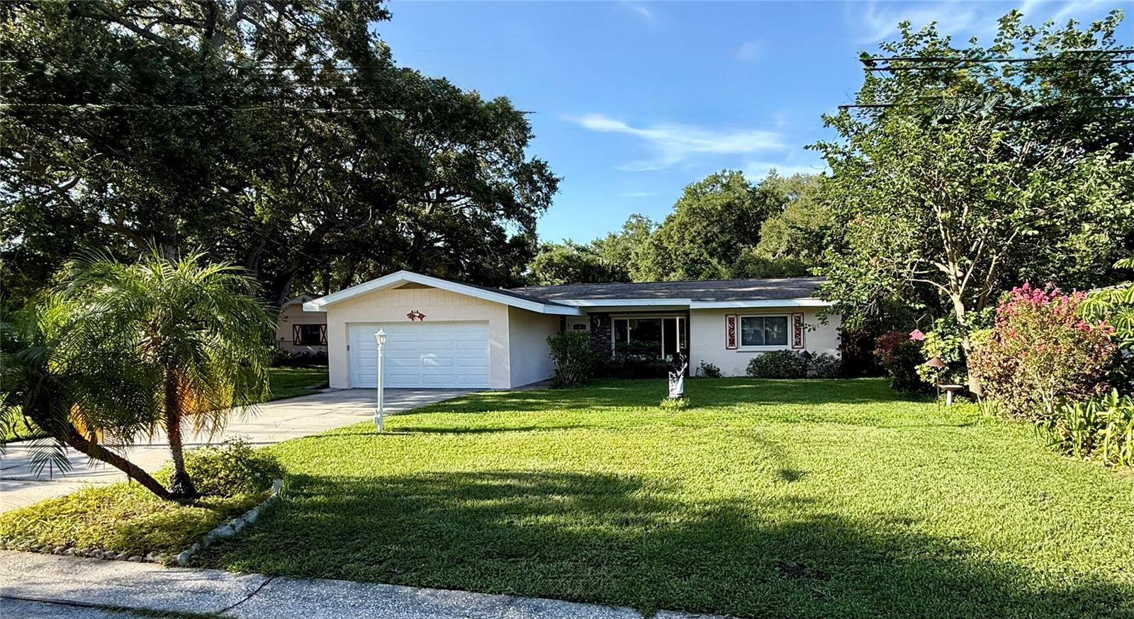 Wow, what an incredible value, location, and package! Situated on an oversized, beautifully landscaped lot of over a half-acre, this home boasts nearly 2,500 square feet of living space and over 3,600 total square feet under roof. Mature trees envelope the property, creating a private oasis with a fully fenced backyard where kids and pets can safely play. 
The versatile split-floorplan design easily accommodates a separate in-law suite. At the heart of the home is a large eat-in kitchen featuring an abundance of cabinet and counter space. It flows seamlessly into the formal dining room and a spacious family room, where you can enjoy views of the yard or cozy up by the wood-burning fireplace on chilly nights. 
The Property Highlights include:
• 4 Bedrooms/4 Baths: 4 spacious bedrooms and 4 full bathrooms offer ultimate privacy.
• Unique and inviting Outdoor Oasis: A screened lanai features a built-in, solar-heated pool perfect for year-round swimming,
as well as plenty of dining and party space
• Bonus Space: Artists and Craftsman will love the large, separate structure serving as the perfect workshop or artist studio.
Conveniently located near top-tier restaurants, shopping, and entertainment, just a short drive to the Capital theater or Ruth Eckerd hall.  This home also offers easy access to two international airports.  Best of all, you can walk or bike right across the Belleair Beach Causeway to enjoy pristine sandy beaches and magical Gulf sunsets every single night!