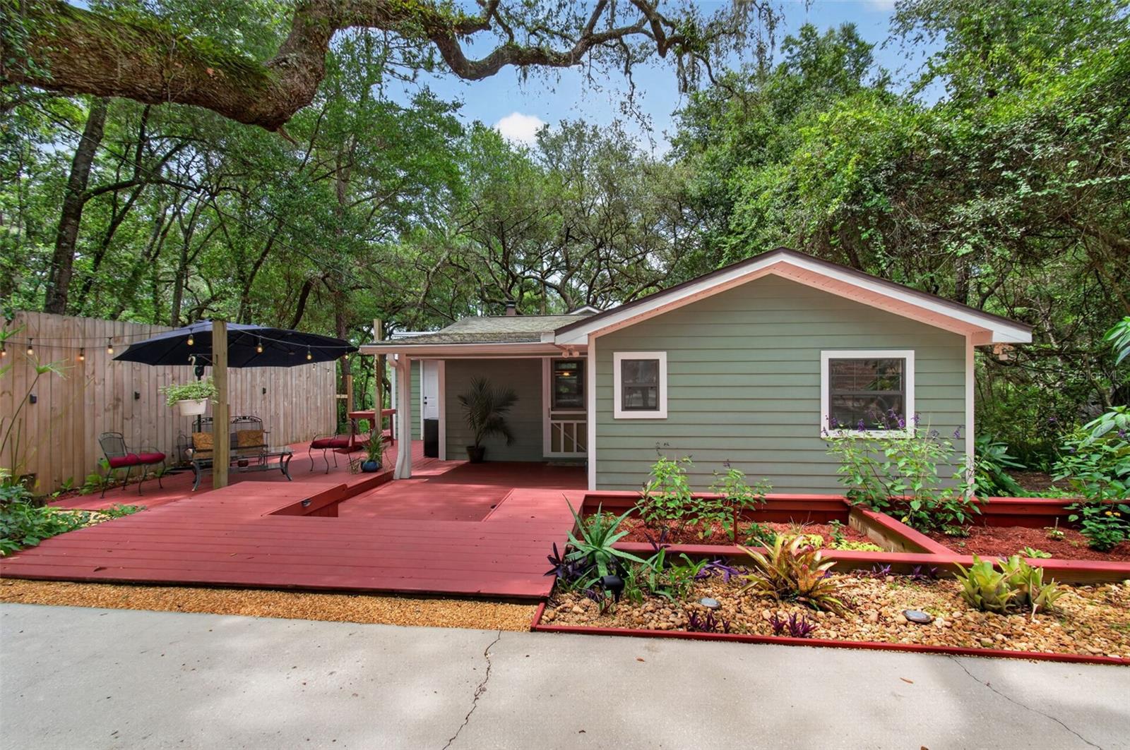 Nestled beneath a canopy of beautiful, mature oak trees, this charming 3-bedroom, 1.5-bath home is full of character and peaceful country appeal. Tucked away on a quiet street just minutes from town, you'll enjoy the perfect balance of privacy and convenience.
Step inside to an inviting open-concept living space featuring stylish concrete counter-tops, open shelving, with plenty of room to cook and converse with friends and family. The thoughtfully designed layout creates a warm and welcoming atmosphere that's perfect for everyday living and entertaining. There is also a spacious laundry room just off the kitchen with plenty of room for storage. Outside, you'll find a thousand square feet of decks that invite you to relax with your morning coffee or unwind after a long day while enjoying the shade of the majestic oaks. An outdoor shower adds a unique touch—perfect for rinsing off after gardening or simply enjoying the fresh air. There is a 12 x 24 aluminum shed on the property. This building would be perfect for storage or would make a great workshop as it is already set up with power. It has a 16x14 foot over-sized pump house excellent for outdoor storage. An additional bonus to this property is 1/20 ownership interest in tract E, located behind the property which accesses Little Lake Bedford. Whether you're searching for your first home, a cozy retreat, or a property with timeless charm, this one offers comfort, character, and a peaceful setting you'll love coming home to.