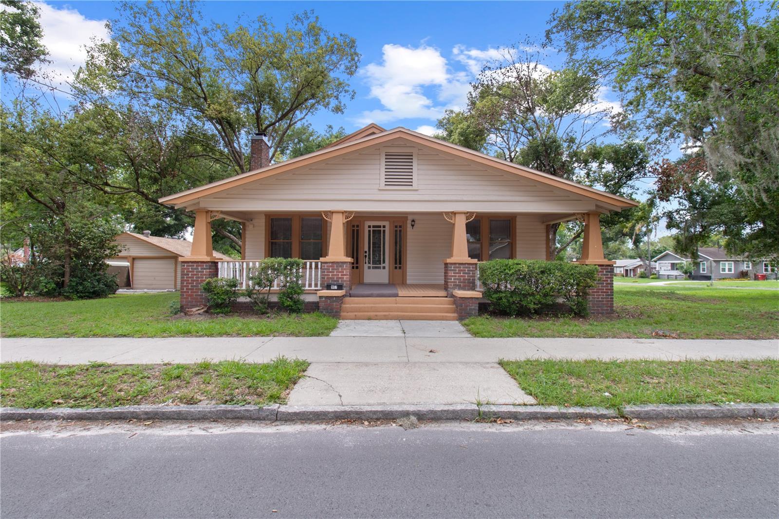 Welcome to this charming 1926 historic home located in the heart of Plant City's sought-after historic district. Offering 3 bedrooms, 2 bathrooms, and 1,781 square feet of living space, this home showcases beautiful original wood floors and a cozy living room with a wood-burning fireplace. The spacious dining room is perfect for gatherings, while the additional rear room provides flexibility as a home office, hobby space, or extra storage. Both bathrooms feature classic clawfoot tubs that complement the home's timeless character. Recent updates include fresh interior and exterior paint, a newer HVAC system, newer water heater, and new kitchen appliances including a refrigerator, range, and dishwasher. Outside, you'll find a detached two-car garage with an automatic door opener and a workshop area for projects and storage. Situated on an oversized 137' x 115' lot shaded by mature trees, this property offers plenty of outdoor space while remaining conveniently located near downtown Plant City. Easy access to Interstate 4 makes commuting to Tampa, Lakeland, and Orlando a breeze.  Call today for your  personal tour.