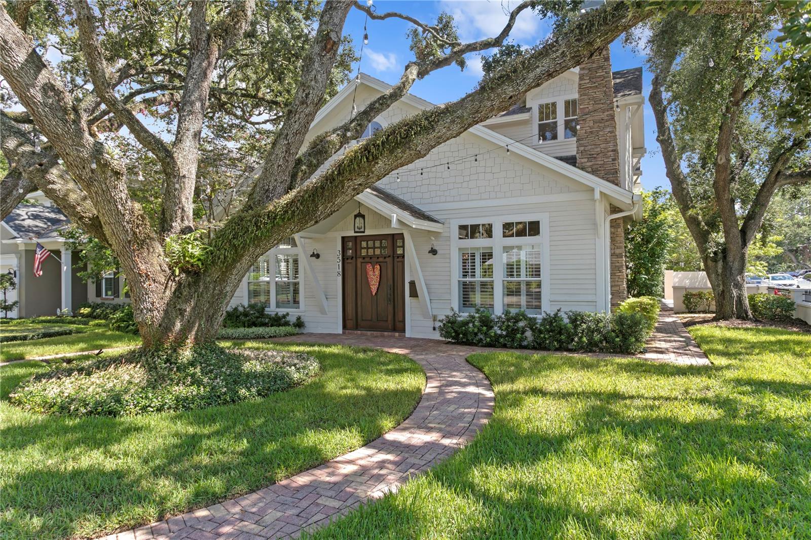 Welcome to this meticulously maintained Craftsman-style home, where timeless architecture meets modern comfort. Built in 2006 yet exuding the charm and craftsmanship typically found only in much older homes, this residence has been lovingly cherished by its owners and offers a warm, classic feel from the moment you arrive. A stately solid wood front door sets the tone, while a grand oak tree provides shade and market lights drape the yard, transforming the exterior into a true South Tampa show-stopper. Inside, volume ceilings, crown molding, custom casing, chair rail details, and an abundance of transom windows fill the home with light and character, complemented by hardwood floors that bring beauty and durability to every space. The formal living room is anchored by a stunning stone-clad fireplace, with the same stone detailing carried elegantly up the home’s exterior side, blending indoors and outdoors in timeless fashion. Designer lighting from Visual Comfort and all-new LED ceiling fixtures (2022) illuminate the home with sophistication, while select rooms have been professionally designed by a well-known local interior design firm. The chef’s kitchen impresses with a Sub-Zero refrigerator, custom cabinetry, and designer accents, opening into comfortable and inviting living and dining spaces that make both entertaining and everyday life a joy. The primary suite is a true retreat, featuring a spa-like en-suite bath with tall ceilings, classic designer plumbing fixtures, dual vanities, a garden tub, and a separate walk-in shower. Throughout the home, you’ll find exceptional closet and storage space with thoughtfully designed storage solutions that make everyday living effortless. Outdoors, enjoy a turf-covered, fully fenced backyard designed for both beauty and low maintenance. Whether enjoying a peaceful family night in or hosting a large celebration—even a wedding—the home flows effortlessly, offering both intimacy and scale to match your lifestyle. Every detail of this home reflects pride of ownership—it has been meticulously maintained and thoughtfully updated to honor its Craftsman heritage while providing modern comfort. A bonus, a brand new roof was installed in June of 2026! Set in one of South Tampa’s most desirable neighborhoods, convenient to premier dining, shopping, and recreation, and zoned for top-rated schools including Plant High, this home offers the rare combination of character, location, and enduring quality. Showings to start on Sunday 6/7!