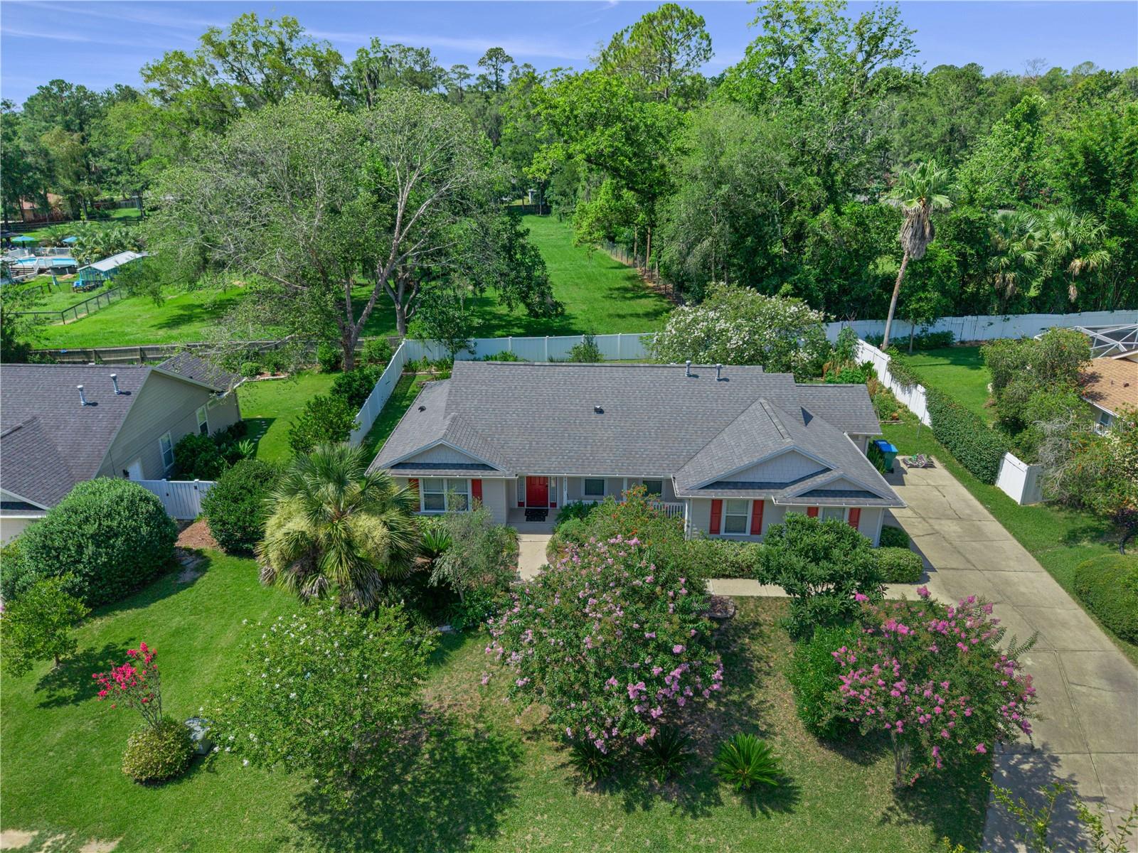 Beautifully maintained 3Bed 2Bath home with a gorgeous garden sanctuary. Renew and relax among Crape Myrtles, Jasmine, Butterfly Ginger, Palms, Canna Lilies & Milkweed attracting butterflies and hummingbirds. Edible landscape with Loquat, Mulberry, Peach, Banana, Lemon, and Blueberry plants, while dedicated garden beds have Cassava, Turmeric, Mexican Spinach and more. Lovingly cared for, this home reflects 15 years of pride of ownership and meticulous maintenance. Inside, you’ll find a desirable split-bedroom floor plan offering comfort and privacy, along with inviting living spaces that flow seamlessly to the enclosed back porch. A covered front porch, side-entry garage, and oversized driveway complete the home’s welcoming curb appeal. Step outside and discover what truly sets this property apart. The fenced backyard has been transformed into a vibrant botanical retreat. Major updates include 2022 roof, newer HVAC system, and a brand-new water heater for peace of mind. Located in the desirable Santa Fe Station community, this home offers the rare opportunity to enjoy a move-in-ready residence with the added beauty and value of a mature landscape that cannot be recreated overnight.  Minutes to everything in Alachua, and 441 &175 for easy access to the Springs and everything in Gainesville.