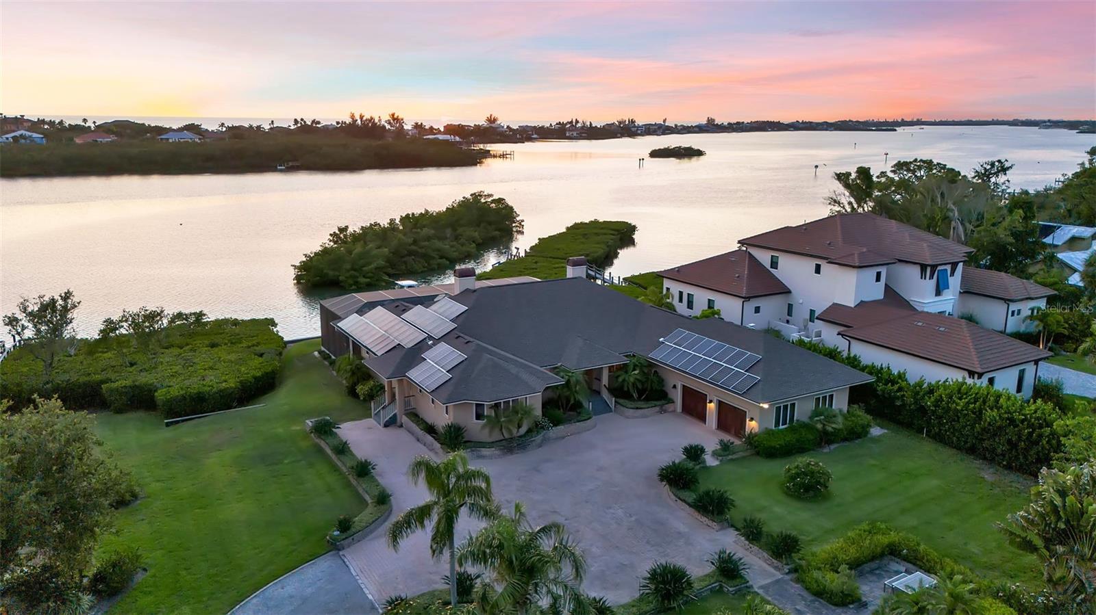 Positioned on 1.9 private waterfront acres with approximately 200 feet of bay frontage, this exceptional estate offers a rare combination of immediate waterfront enjoyment and long-term flexibility. With multiple docks and direct access to Sarasota Bay, the property is ideally suited for those seeking an authentic waterfront lifestyle defined by boating, fishing, recreation and effortless access to the Gulf Coast's most desirable destinations. Spanning approximately 2,960 square feet under air, the residence blends rich architectural detailing with panoramic water and nature views throughout. Wood-trimmed windows, doors and millwork, tray ceilings, recessed lighting, large-format tile flooring and extensive custom cabinetry create a warm yet elevated atmosphere. The open-concept layout is anchored by a spacious great room featuring a built-in gas fireplace, custom entertainment wall and expansive sliding glass doors that create seamless indoor-outdoor flow. The kitchen is designed for both entertaining and everyday living with a Viking dual-oven gas range with integrated griddle and char broiler, Sub-Zero refrigerator, Bosch dishwasher, custom wood cabinetry, decorative copper lighting, integrated wine storage, center island with prep sink and a waterfront breakfast nook with terrace access. The primary suite serves as a private retreat with French doors to outdoor living areas, water and pool views, a custom walk-in closet and a spa-inspired bath featuring a Jacuzzi tub, dual vanities and an oversized walk-in shower. Additional spaces include a private office, guest suite and flexible bonus/game room complete with projector screen, surround sound system, wet bar, beverage refrigerator and French doors opening to the outdoor areas. Outdoor living is thoughtfully designed with an upper-level covered waterfront terrace, raised spa, screen-enclosed resort-style pool terrace, multiple lounge areas and tropical landscaping overlooking the water. For boating enthusiasts, the property features a new private composite dock with a 12,000-pound Deco boat lift, water and electric service, fish cleaning station and deep-water access and a second dock. Completing the property is an attached 2-car garage and a rare detached air-conditioned garage complex with capacity for up to 7 vehicles, workshop space, office area and extensive storage for boats, golf carts, trailers and recreational equipment. The property presents a potential opportunity for future division into two distinct waterfront homesites, each benefiting from approximately 100 feet of water-frontage. The northern parcel would encompass the existing residence and detached garage complex, while the southern parcel offers the potential for a premier bayfront homesite. Beyond its exceptional development potential, the estate delivers deep-water boating access, expansive garage capacity and thoughtfully designed indoor-outdoor living. The property is just moments from waterfront dining, marinas and beaches that define the Gulf Coast lifestyle. Nokomis Beach, Venice Island, Legacy Trail, Casey Key, Oscar Scherer State Park and downtown Venice are all nearby, while quick access to Sarasota, the barrier islands and Interstate 75 allow for effortless travel throughout the region. Combining acreage, waterfrontage, boating infrastructure and exceptional garage capacity, this is a rare opportunity to experience the best of Florida waterfront living.