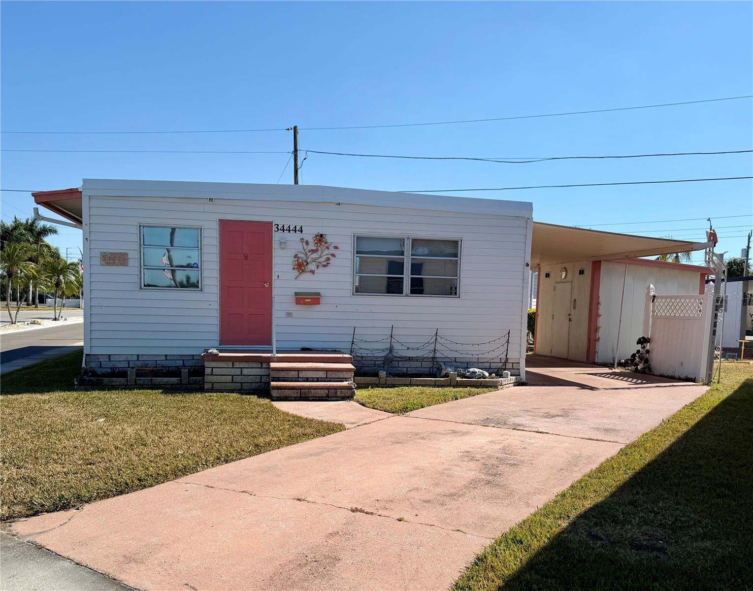 VOTED ONE OF THE TOP 5 RETIREMENT COMMUNITIES IN 2025!!   Move-in ready double-wide mobile home offering 2 bedrooms and 2 full baths, ready for you to update to your taste. Home comes fully furnished; turn-key, only personal items will be removed. New roof in 2025! HVAC 2017 The large primary suite includes a walk-in closet, added storage in the en-suite bath, and double sinks. Generously sized bedrooms with excellent storage. Extended driveway fits three vehicles.  Sunset Palms is 1 of Pinellas County‘s best kept secret in my opinion, very inexpensive living at only $210 per month which includes all the amenities one could want; WATER/SEWER/TRASH, owned clubhouse, escrows are fully funded, beautiful heated pool and spa, fitness center, library, shuffleboard, billiard table, and a small lake at the back of the park, laundry room, and your very own private entrance to the super Walmart… On foot, bicycle or golf cart… Etc., etc. This location is close to churches, shopping, restaurants, approx 20-30 minutes to the beach or Tampa Int’l Airport. Jump on I-275 to Tampa, Sarasota, etc.