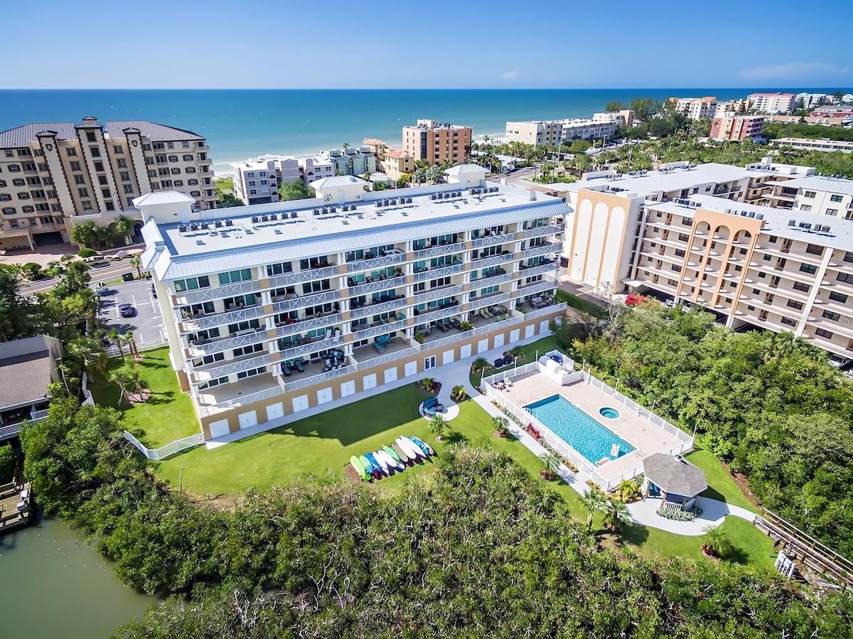 Experience maintenance-free waterfront living in one of Indian Shores’ most desirable communities. This RARELY AVAILABLE Dolphin Key condo residence combines luxury, location, and lifestyle—offering the perfect blend of beach access, BOATING convenience, and modern elegance. Built in 2017, this luxurious 2nd-floor, END-UNIT residence offers exquisite craftsmanship, designer finishes, and sophisticated coastal contemporary style throughout. Professionally decorated and being offered FULLY FURNISHED, this stunning waterfront condo is truly turnkey and ready for your personal getaway or as a PERFORMING INVESTMENT PROPERTY. Located in the highly sought-after Dolphin Key Condos in Indian Shores, this premier corner residence delivers incredible, unobstructed views of the Intracoastal Waterway. Just steps from miles of crystal award-winning sand beaches, the community also features PRIVATE DOCK ACCESS, a resort-style heated pool and spa, waterfront recreation deck, kayak storage, gazebo, fire pit, boardwalk promenade, and barbecue grilling area—offering endless opportunities for boating, fishing, kayaking, or simply relaxing by the water. Across the street, enjoy convenient Gulf BEACH ACCESS and breathtaking sunset views. This beautifully appointed 3-bedroom, 2-bath home features an OPEN FLOORPLAN designed for effortless entertaining. The kitchen, dining, and living areas flow seamlessly together, highlighted by high ceilings, and IMPACT-RATED triple sliding doors that open to an EXPANSIVE 20' x 30' balcony overlooking the water. The outdoor space serves as a true extension of the living area—perfect for morning coffee, evening cocktails, or watching dolphins pass by. The gourmet kitchen is thoughtfully designed with granite countertops, stainless steel appliances, custom cabinetry, and a large breakfast bar that anchors the home. The spacious master suite is a private retreat with direct access to the balcony through TRIPLE SLIDERS, complete with a king-size bed, two walk-in closets, dual vanities and a large two-person walk-in shower. Two additional generously sized bedrooms with large closets offer comfort and versatility, with plantation shutters and views of the Gulf of Mexico. Additional highlights include hurricane-rated doors and windows, Nest thermostat, tile flooring, inside full-size laundry, and TWO ASSIGNED PARKING SPACES—one covered under the building and one exterior space, plus ample guest parking. Whether you prefer to spend your days on the beach, morning Joe at the Voila-Merci French bakery in front, dining at nearby local favorites like the award-winning Salt Rock Grill, or exploring Historic John’s Pass with its water sports, dolphin cruises, and seafood restaurants, this location offers the best of Florida’s coastal lifestyle. Enjoy the Town's parks, playgrounds, exquisite restaurants, active tennis & pickleball courts, and world-famous wild sea bird sanctuary. This property can be and has been RENTED MONTHLY with an available PROPERTY MANAGER IN PLACE, with strong verifiable rental history and confirmed future reservations. Wait no longer, take advantage of this golden opportunity now!