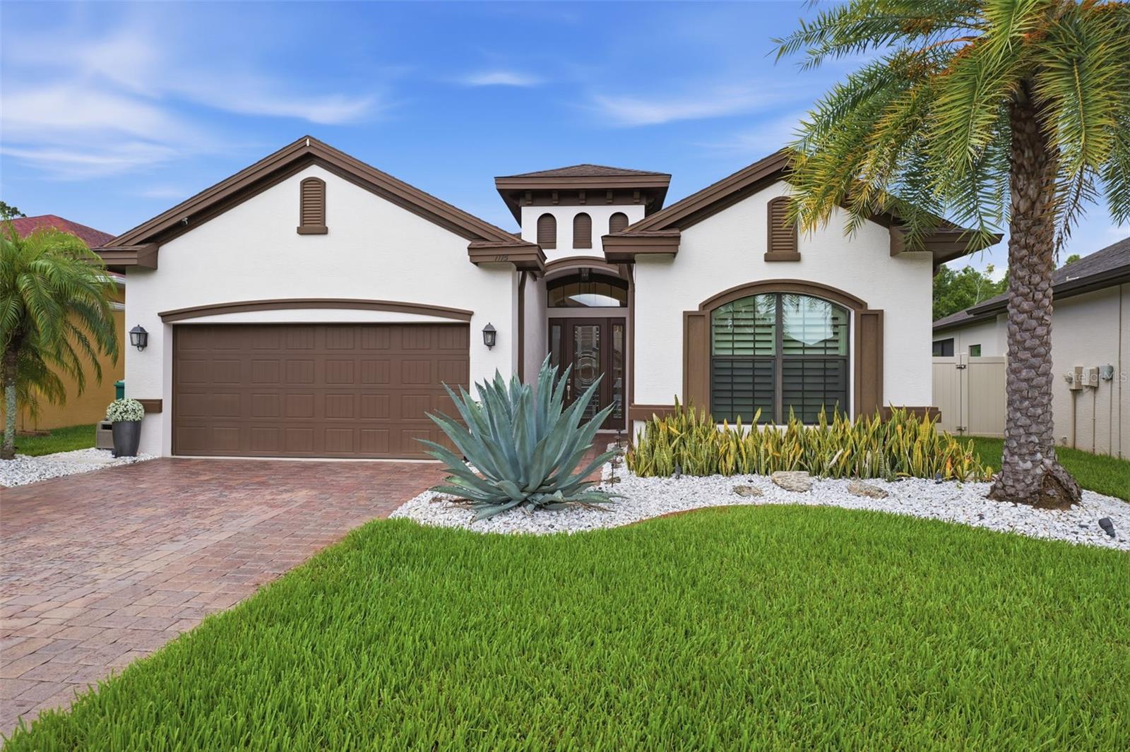 Welcome to 1115 Ketzal Drive, an exceptional custom-built Samuelsen residence nestled in the heart of Trinity, where luxury, privacy, and thoughtful design come together seamlessly. Located within Trinity East, one of Trinity's most desirable gated communities, this meticulously renovated home offers the perfect blend of elegance, comfort, and convenience. With NO CDD fees and a low HOA, this remarkable property showcases premium upgrades throughout, completed in 2024 with no expense spared. From the moment you enter, you'll be captivated by the elegant engineered hardwood flooring and tile that flow throughout the home completely carpet-free for timeless beauty and easy maintenance. Every detail has been carefully curated to create a sophisticated yet comfortable living experience. The stunning gourmet kitchen serves as the centerpiece of the home, featuring solid wood cabinetry with custom glass-front accents, breathtaking waterfall countertops on the oversized center island, a convenient pop-up charging station, and brand-new stainless steel appliances. Adjacent to the kitchen, the charming breakfast nook offers built-in seating with hidden storage, creating the perfect space for casual dining and gathering. Retreat to the spacious primary suite, a true sanctuary highlighted by double tray ceilings, a custom-designed closet system worthy of a luxury estate, and a beautifully appointed en-suite bath. Private access from the primary suite leads directly to the expansive pavered lanai, where tranquil water and conservation views provide a picturesque backdrop for relaxation. Designed for both entertaining and everyday enjoyment, the formal dining room showcases a striking designer feature wall accented by elegant sconces, creating a warm and sophisticated atmosphere. Step outside to the extended screened lanai and discover one of the property's most impressive features, breathtaking water and conservation views with no rear neighbors, offering privacy at its finest. The fully fenced backyard provides additional space for pets, play, and outdoor enjoyment. Adding to the home's appeal are energy-efficient solar panels, resulting in an average monthly electric bill of approximately just $33, offering exceptional efficiency without sacrificing comfort. Conveniently located near top-rated schools, premier shopping, dining, and major highways, this extraordinary home combines the craftsmanship of a custom-built Samuelsen residence with modern luxury upgrades, stunning natural views, and an unbeatable Trinity location. The next fortunate owners are truly in for a treat! Call to schedule your private tour.