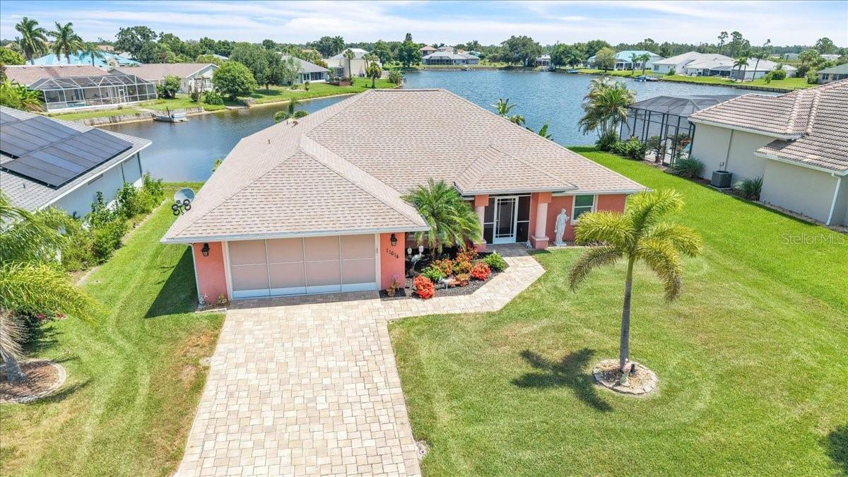 Welcome to this beautifully maintained custom-built lakefront home in the charming community of Lake Suzy Estates, a hidden gem in DeSoto County. Offering 3 bedrooms, 2 bathrooms, a den, and over 2,000 square feet of thoughtfully designed living space, this residence perfectly blends style, comfort, and functionality. From the moment you arrive, the inviting curb appeal, paver driveway, and lush tropical landscaping create a warm welcome, while the spacious two-car garage features a convenient sliding screen for added versatility. Inside, the home shows like a model with elegant tray ceilings, crown molding, hurricane-impact windows and doors, and a desirable split-bedroom floor plan designed for both privacy and everyday living. Double doors open to a versatile bonus room, ideal for a home office, den, library, hobby room, or guest space. The open-concept great room serves as the heart of the home, offering a bright and inviting space ideal for relaxing or entertaining. Tile flooring flows throughout the main living areas, creating a seamless connection between the living room, dining area, and kitchen. French doors flood the space with natural light and open to the lanai, effortlessly blending indoor and outdoor living while showcasing tranquil lake views. The well-appointed kitchen overlooks the main living area and is thoughtfully designed for both beauty and efficiency. Features include rich wood cabinetry with crown molding, granite countertops, a stylish tile backsplash, stainless steel appliances, abundant counter space, and a pantry closet for additional storage. The expansive breakfast bar provides ample seating, making it the perfect gathering spot for casual meals or entertaining guests. Conveniently located just off the kitchen, the laundry room offers direct access to the garage.  The private primary suite serves as a true retreat with large walk-in closets and a luxurious ensuite bath. The split-bedroom floor plan provides privacy for both owners and guests. Two generously sized guest bedrooms feature plush carpet flooring and large built-in closets, offering comfortable accommodations and ample storage space. The guest bedrooms share a well-appointed bathroom featuring a Roman-style walk-in shower, creating a convenient and inviting space for family and visitors alike. Step outside to the oversized paver lanai and take in serene lake views or follow the path to your private dock with low-maintenance Trex decking—ideal for electric boating, fishing, birdwatching, or simply unwinding in nature. Meticulously cared for and move-in ready, this exceptional home offers the perfect balance of comfort, style, and waterfront tranquility.  **PLEASE ENJOY THE 3D INTERACTIVE VIRTUAL TOUR ASSOCIATED WITH THIS LISTING**