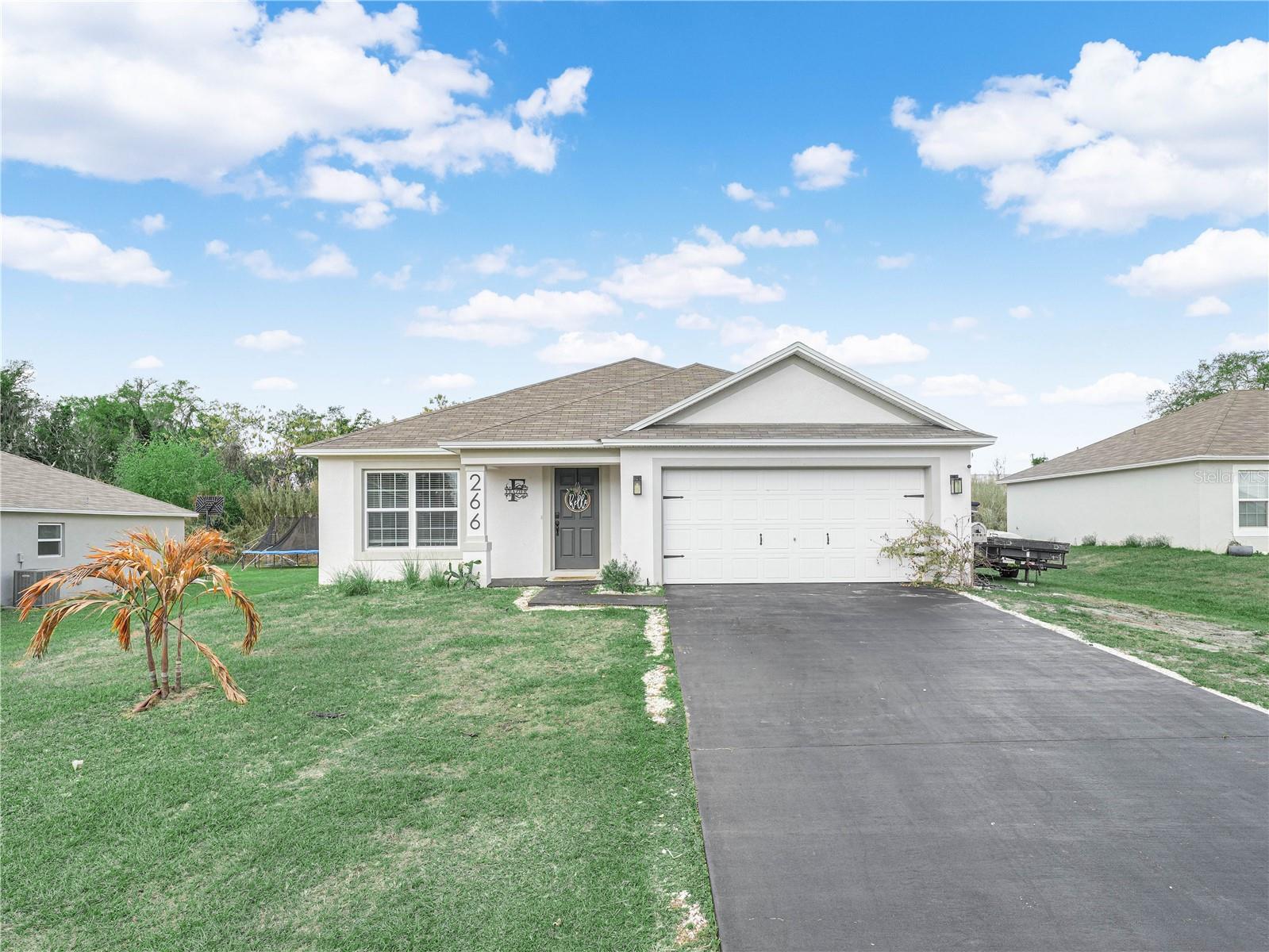 Welcome to this beautifully maintained 4-bedroom, 2-bathroom home, built in 2023 and located just minutes from downtown Frostproof. With no HOA, this property offers freedom and convenience. Enter through a welcoming and convenient entryway that leads into a bright dining room. The dining area is generously sized, ideal for hosting family dinners. The kitchen features stone countertops, a large island with bar-top seating, stainless steel appliances, and a dedicated laundry room conveniently located just off the kitchen. The living room and kitchen flow seamlessly, creating a great room that is welcoming and perfect for entertaining. The large master bedroom is spacious, complete with dual vanities in the master bath and a spacious walk-in closet. Additional highlights include a 2-car garage, large driveway, and a full irrigation system. The garage does have a mini-split A/C system, ready to be used as an extra hangout space. The large paver back patio is ideal for entertaining guests and enjoying the fresh air. Washer, dryer, and shed do not convey with the property.
