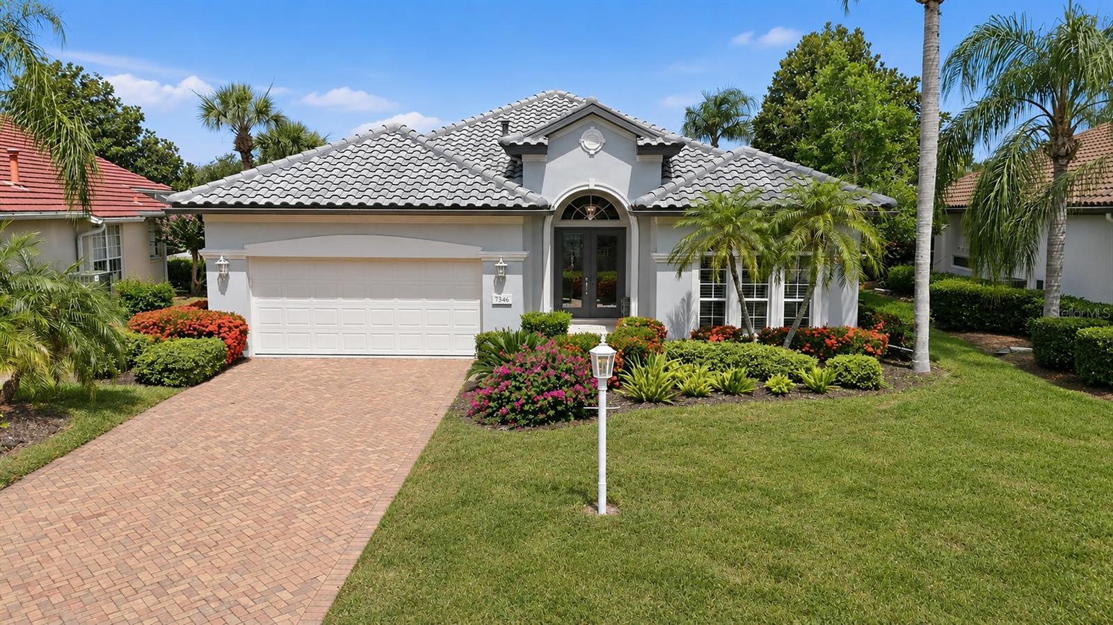 Experience refined Florida living in this beautifully maintained and thoughtfully updated 3-bedroom, 2.5-bath residence located within award-winning University Park Country Club. Showcasing a modern aesthetic, this home features tall ceilings, crown molding, architectural details, hand-scraped hardwood & tile flooring, & an open-concept floor plan designed for both everyday living & entertaining.   Major updates include a NEW TILE ROOF and WATER HEATER installed in 2024, a new HVAC SYSTEM installed in 2019 and an AIR PURIFICATION SYSTEM in 2026, & EXTERIOR PAINTING in 2024, providing peace of mind for years to come.

The attractive paver driveway and walkway are framed by colorful tropical landscaping, while the tiled front porch with decorative mosaic creates a welcoming first impression. Double leaded-glass entry doors with a transom window open to a bright foyer that flows seamlessly into the spacious living and dining areas, complete with built-ins, a modern ceiling fan, and triple sliding glass doors that bring the outdoors in. 

The beautifully updated kitchen is the heart of the home, offering quartz countertops, newer stainless steel appliances, white cabinetry, under-cabinet lighting, a built-in pantry, and a raised breakfast bar accented with decorative tile that complements the backsplash. A separate beverage station features a wine refrigerator and glass-front cabinetry, creating the perfect space for entertaining. The sunny breakfast nook includes an aquarium window, Bermuda shutters, and a charming window seat with a view of the lanai. 

The spacious primary suite serves as a private retreat with a sitting area, lanai access, abundant windows, a feature wall, modern ceiling fan, and two custom-fitted closets. The ensuite bath features dual vanities, a soaking tub, and a large walk-in shower. 

Guest accommodations include a bright bedroom with Bermuda shutters and custom closet built-ins, plus a well-appointed bath with granite countertops and a tub/shower combination enclosed by a stylish glass barn door. A versatile third bedroom with glass French doors and a modern ceiling fan can easily function as a home office or den.

Outdoor living is equally impressive. The expansive paver lanai showcases a sparkling pool with a tranquil waterfall, an outdoor prep area with a built-in Lynx grill and hood, and SPF outdoor shade and a convenient pool bath. Relax and entertain while enjoying picturesque lake views in a private tropical setting. 

Additional features include a laundry room with utility sink & upper cabinetry, leading to the attached two-car garage. Residents of Wentworth enjoy the convenience of landscape maintenance-free living and access to a community pool shared with neighboring Notting Hill.  This exceptional home offers the perfect blend of style, comfort, & resort-inspired living in one of the area's most sought-after golf and country club communities.  

UPCC is consistently ranked one of the top courses in Florida featuring 27 holes of championship golf; tennis and pickleball; fitness center, croquet – as well as an array of social and group activities.  Just a 15-minute drive outside this peaceful enclave is downtown Sarasota and two miles east of UPCC is the convenience of I-75, University Town Center, Nate Benderson Park and Mote Marine Aquarium.  Enjoy the club amenities with the required minimum of a Social membership at UPCC, which is owned by the residents through a Recreation District.