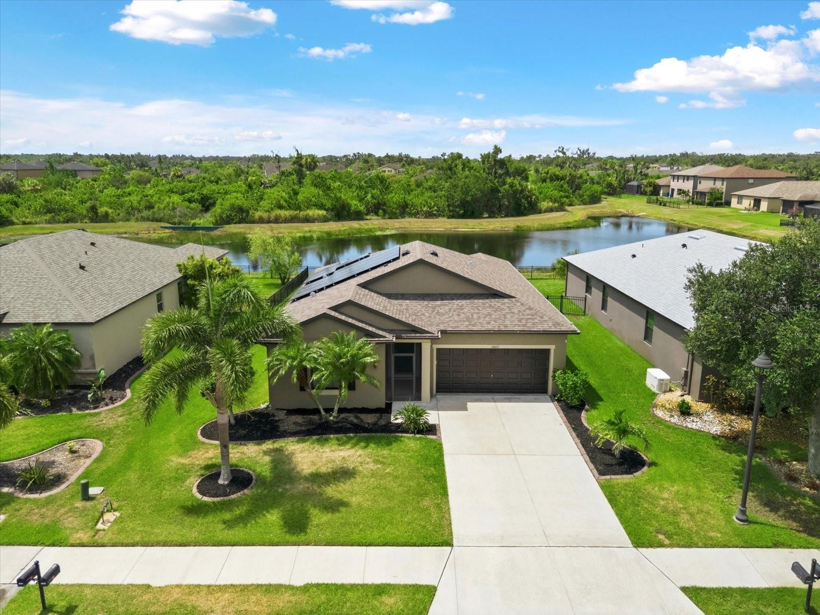 MOVE-IN READY and ASSUMABLE MORTGAGE for qualified buyers and LOW HOA FEES ($150/yr). With WATER & PRESERVE VIEWS, this well-maintained 3 bedroom, 2 bath home features an open floorplan and just under 1,500 sqft of one level living. The spacious kitchen offers NEWER stainless appliances (2025/2026), ample cabinetry, a large center island, tiled backsplash, a pantry and overlooks the large family room with plenty of space for relaxing or entertaining.  Retreat to your primary suite with an en-suite bath and walk-in closet.  Two additional bedrooms and a full bath are thoughtfully positioned on the opposite side of the home for privacy. The laundry room, located just off the kitchen, includes the WASHER & DRYER and garage access which has a utility sink. Sip your morning coffee on the oversized screened-in lanai with clear view screens and unobstructed views of the pond. ADDITIONAL FEATURES: FENCED backyard, Hurricane shutters, SOLAR PANELS & battery back up (paid off), NEWER ROOF (2025), NEWER HVAC (2022/2023) tile and LVP flooring throughout (no carpet), 4 zone Rain Bird irrigation system, neutral tones, mature landscaping, screened front entry with epoxy coated flooring (2026), attic storage, and fresh exterior paint.  AMENITIES: Harrison Ranch offers a relaxed, active lifestyle with resort-style amenities, including: Heated junior Olympic-size pool, tennis & pickleball courts, basketball court, Clubhouse, fitness center, game room, 2 playgrounds, multi-purpose sports fields, picnic areas, library, and over 5 miles of walking and nature trails. LOCATION: Conveniently located between major employment hubs in St Petersburg (30 miles), Tampa (45 miles) and Gulf Coast beaches near Bradenton and Sarasota, you’ll find essential shopping, dining, medical facilities, airports, and schools nearby.  Ready to make it yours? Schedule a tour today. Some photos have been virtually staged.