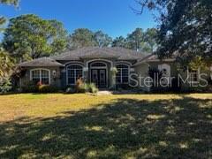 Clean, well-maintained 3-bedroom plus den, 2-bath home with a 3-car garage on 2.72 acres. Nearly 2,100 sq ft of living space featuring a great room, formal dining room, and separate den. High ceilings, abundant natural light, and numerous windows throughout. Beautifully cared for, with a large screened lanai. Peaceful setting with mature pine and palm trees.