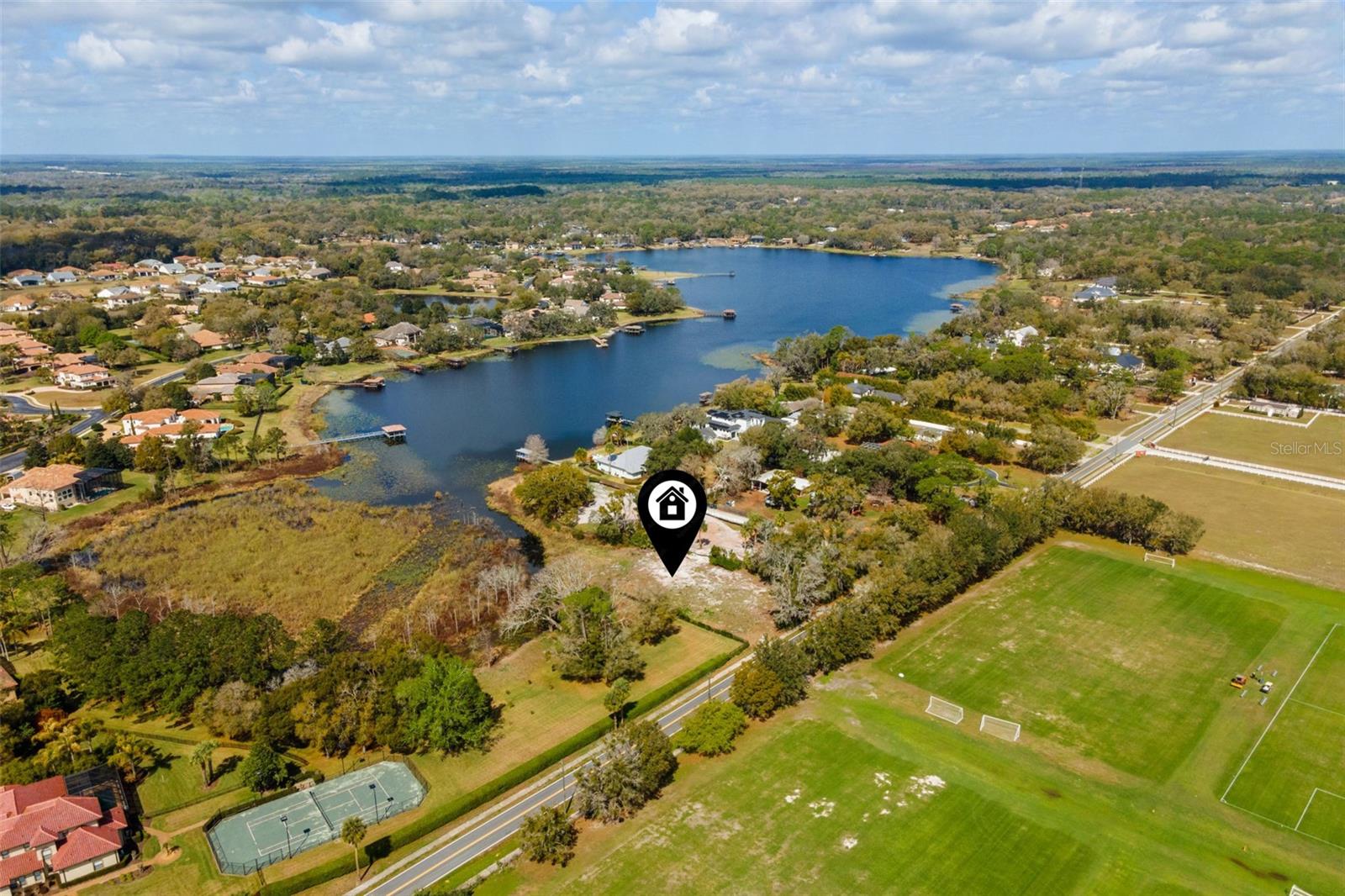 Pre-Construction. To be built. Introducing an extraordinary lakefront custom estate on 1.40 acres along Lake Markham.  Crafted by award-winning WJ Homes, discover 6,241 square feet of expertly designed living space. This stunning residence features five spacious en-suite bedrooms, each with private baths and walk-in closets, along with an additional full bath in the office for added versatility. Thoughtfully designed for both comfort and functionality, the home includes an upstairs study loft, a secondary loft off the game room, and a flexible gym/yoga studio or office conveniently located off the primary suite. The expansive open-concept layout showcases a grand great room and casual dining area that flow seamlessly into the gourmet kitchen and covered lanai, complemented by a formal dining room perfect for elevated entertaining. Exceptional convenience is found throughout, with a butler’s pantry, oversized walk-in pantry, combined laundry and mudroom, and an extended three-car garage. The chef’s kitchen is truly a showpiece, highlighted by a 48-inch six-burner cooktop, along with a hidden butler’s pantry equipped with a double oven, secondary sink, and additional dishwasher. A dedicated refrigerator in the walk-in pantry adds even more functionality. Schedule your private appointment to review the curated design lookbook and discover the refined finishes and selections planned for this remarkable lakefront home.  PHOTOS ARE OF BUILDER'S MODEL HOME AND NOT OF HOME TO BE BUILT AT 2080 LAKE MARKHAM.