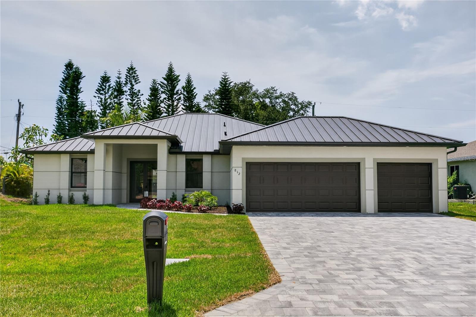 Discover refined COASTAL CONTEMPORARY living! Move-in-ready NEW CONSTRUCTION HOME (2026) complete w/ 2-10 HOME WARRANTY! Located in SW Cape Coral, offers NO FLOOD INSURANCE, durable METAL ROOF, 3-CAR GARAGE & CITY WATER & SEWER! $1,800-$2,400/year homeowners' insurance! Enjoy easy access to CHIQUITA BLVD & PINE ISLAND RD, making commuting & daily errands easier! This CONTEMPORARY LUXURY HOME features SCREENED, HEATED POOL & SPA & 4 BEDS (2 primary suites) & 3 full BATHS, layout is ideal for EVERYDAY LIVING & ENTERTAINING! SCREENED LANAI provides PERFECT SETTING TO RELAX in SPA, SWIM in HEATED POOL, or HOST UNFORGETTABLE BBQs while enjoying THE BEST OF SWFL LIVING! Bright, open layout w/ LIGHT NEUTRAL TILE FLOORING throughout. IMPACT-RESISTANT DOUBLE DOORS lead into WELCOMING LIVING ROOM w/ 12-ft VAULTED CEILING & SLIDING DOORS TO LANAI. GORGEOUS CHEF’S KITCHEN showcases sophisticated CUSTOM CABINETRY w/ NATURAL WOOD-GRAIN finish paired w/ sleek WHITE FLAT-PANEL UPPER CABINETS. Warm cabinetry tone features elegant EUROPEAN OAK-style texture w/ organic grain movement. Crisp QUARTZ COUNTERTOPS & matching FULL BACKSPLASH complement the modern palette, while UNDER-CABINET LED LIGHTING enhances the bright, open feel. Equipped w/ SS appliances, French-door refrigerator, microwave, smooth-top range & angular EURO-STYLE hood & dishwasher. Oversized ISLAND & minimalist HARDWARE-FREE CABINETRY. Built-in BUTLER’S PANTRY w/ warm WOOD-GRAIN cabinetry, sleek WHITE upper cabinets, QUARTZ countertops, under-cabinet lighting & built-in WINE REFRIGERATOR, ideal for BEVERAGE STATION, COFFEE BAR, or EXTRA STORAGE & PREP SPACE. DINING ROOM w/ bright, modern design, neutral tones & vaulted ceiling w/ recessed lighting that enhances open feel. LARGE PICTURE WINDOW brings in natural light & offers views of screened lanai & pool/spa. LARGE PRIMARY SUITE w/ sliding doors to lanai, WALK-IN CLOSET w/ BUILT-IN SHELVING & HANGING RACKS & LUXURIOUS PRIMARY BATHROOM w/ spacious WALK-IN GLASS SHOWER w/ floor-to-ceiling designer tile, rainfall showerhead, built-in bench & modern matte-black fixtures. Dual sink vanity w/ quartz countertops, sleek white cabinetry & contemporary lighting complements the spa-like design. Private water closet & generous natural light create BRIGHT & SERENE RETREAT! BUILT-IN CUSTOM CLOSET WHITE CABINETRY provides ADDED STORAGE & CLEAN, UPSCALE LOOK. SPLIT LAYOUT offers SECOND PRIMARY SUITE w/ POOL BATHROOM & TWO GUEST BEDROOMS w/ HALL BATHROOM for added privacy. Step outside to SCREENED LANAI w/ HEATED POOL & SPA, landscaped surrounding & FULLY EQUIPED OUTDOOR KITCHEN w/ BUILT-IN stainless steel BBQ GRILL, SINK, BEVERAGE REFRIGERATOR, GRANITE COUNTERTOPS & MODERN BACKSPLASH, ideal for OUTDOOR DINING & ENTERTAINING! PAVER FLOORING & CEILING FAN create COMFORTABLE SPACE for YEAR-ROUND ENJOYMENT. LAUNDRY, 3-CAR GARAGE & long-lasting METAL ROOF complete HOMES' FUNCTIONAL FEATURES. Run, it won’t last w/ all these LUXURY FEATURES & SWFL lifestyle amenities!