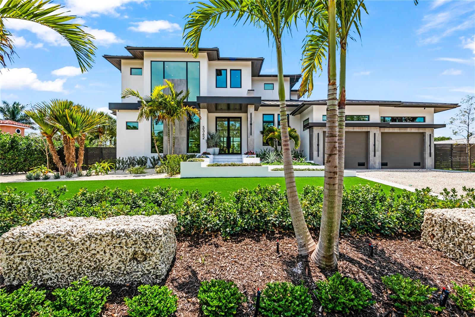 Experience elevated coastal living in this award-winning “Marlin Model” by Nutter Custom Construction, perfectly positioned on Siesta Key’s coveted Grand Canal. Completed in 2023 and showcased as the builder’s signature home, this completely custom Yacht-Modern residence blends refined elegance, contemporary design, and exceptional waterfront functionality. With 4,294 sq. ft. under air and 6,405 total sq. ft., this home offers 3 ensuite bedrooms (please note gym can be converted into 4th bedroom), 3 full baths, 2 half baths—including a dedicated pool bath—plus multiple flexible indoor and outdoor living spaces ideal for relaxed luxury and entertaining. Floor-to-ceiling glass doors reveal sweeping water views and seamless indoor-outdoor flow. Elevated construction and smart-home technology offer modern security and peace of mind. No water intrusion or damage during recent hurricanes. The chef’s kitchen is a standout, featuring a 10-ft waterfall island, European white dolomite counters, hidden walk-in pantry, Wolf appliances, built-in coffee system, under-cabinet toe lighting, and formal dining with wine cooler and ice maker.
The primary suite is a private retreat with dual walk-in closets, hidden entry doors, freestanding soaking tub, oversized designer shower and steam room, and private outdoor shower garden. Outside, enjoy resort-style living with a multi-level pool and raised spa with infinity spillover, expansive lounging deck, covered living and dining with motorized screens, full outdoor kitchen, turf backyard with putting green, and multiple terraces. For boating enthusiasts, the property offers 104 ft of waterfront, a new concrete seawall, 104 ft of composite dock, two Golden Gear boat lifts with remotes (20,000lb & 5,000lb), water and shore power. Hop on your boat and be in the Gulf in less than 15 minutes.  This property has received prestigious recognition, earning Best Custom Home, Best Kitchen, and Best Staircase in the Parade of Homes awards — reflecting exceptional craftsmanship and design distinction.
The oversized 2.5-car garage provides excellent storage and functionality, offering space for a golf cart or the option to create a golf simulator setup. Located in Siesta Isles with a voluntary HOA, less than one mile to Siesta Key Beach and moments to Siesta Village by golf cart or bike. Click on the Virtual Tour Link to get a behind the scenes look! ** Furniture negotiable