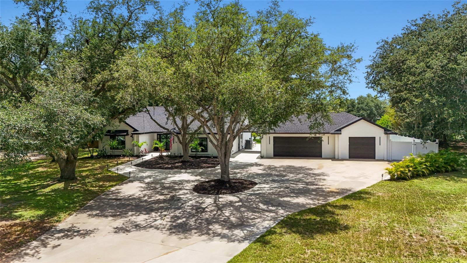 Welcome to your own private retreat in the highly sought-after Mill Creek community. Situated on over an acre with serene water views, this stunning 4-bedroom, 2-bathroom home has been completely transformed with modern finishes, thoughtful upgrades, and nearly every major improvement already completed for you. From the moment you arrive, the attention to detail is evident - from the expansive circular driveway, new roof, hurricane-impact windows and doors, updated landscaping, and new concrete walkway to the beautifully renovated interior beyond. Inside, the open-concept floor plan is flooded with natural light thanks to additional windows and an expanded slider system, creating a bright and inviting space that's perfect for everyday living and entertaining. At the heart of the home is a designer-inspired kitchen featuring quartz countertops, soft-close cabinetry, double ovens, an induction cooktop, beverage refrigerator, and contemporary finishes throughout. Luxury vinyl plank flooring, recessed lighting, and an electric fireplace add both style and functionality. The spacious primary suite offers a beautifully updated en-suite bath with dual vanities and a stunning walk-in shower. The guest bathroom has also been fully renovated with dual sinks, a new shower, and modern finishes. Custom built-in closet systems throughout the home provide exceptional storage and organization. Step outside and enjoy the best of Florida living. The backyard features a brand-new pergola, in-ground hot tub, and peaceful water views, creating the perfect setting to relax or entertain. With over an acre of land, there's still plenty of room to add a future pool, guest house, or additional outdoor amenities. The property offers fenced access on both sides of the home, including a removable fence section that provides convenient access for RV, boat, or trailer storage. The 3-car garage offers incredible flexibility, with one bay currently set up as a home gym while the remaining garage space remains fully functional and includes a utility sink. Additional storage is available with two attic spaces - one in the home and one in the garage. Additional major improvements include a new A/C system and ductwork, updated lighting throughout, a recently serviced septic system, and countless upgrades that make this home truly move-in ready. Mill Creek is known for its larger homesites, low HOA fees, and convenient location. Publix is located just outside the community, while Costco, Target, Whole Foods, dining, and shopping at The Marketplace at Heritage Harbour are only minutes away. Residents also enjoy easy access to Lakewood Ranch, UTC, I-75, top-rated schools, golf courses, and some of the Gulf Coast's most beautiful beaches. Opportunities like this don't come along often - where modern design, major upgrades, acreage, water views, and a prime location come together in one exceptional property.