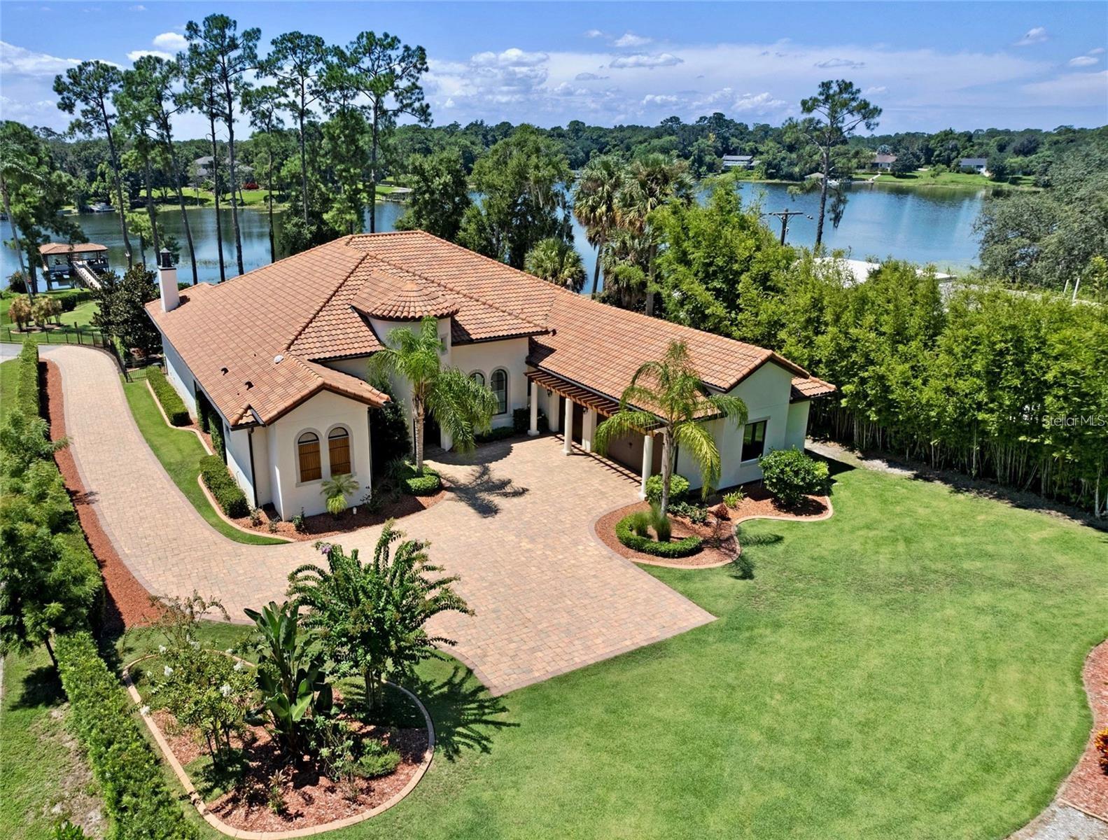 This is a must see, one-of-a-kind LAKEFRONT gem! Bring your boat, fishing pole and bathing suit to your new home! This magnificent, Custom Lakefront home sits on the desired, private Lake Mary Ski Lake with Covered DOCK and LIFT! The home is nicely nestled on almost 2 acres of plush, immaculate land. Located in the sought-after Lake Mary Waterside Community. This unique home has 4 bedrooms, 4 baths (2 are half baths), and the 4th bedroom is detached off the outside summer kitchen. Ideal for an In-Law Suite or Private Office. Oversized master bedroom with a large, custom walk-in closet. Stunning Master bath with dual sinks and a decorated a large walk-in shower. A brilliant floor plan as you walk through the large foyer to the Formal Living area and grand great room. This home boost of distinctive detail in every way. Tongue and Groove Cypress Ceiling, Crown Molding and so much more. Plantation Shutters! Every room with the most stunning views of the brilliant landscaping and stunning LAKEFRONT. Travertine flooring throughout most of the home and Wood/ Custom Tile in other rooms; no carpet. Upgraded baseboards and crown molding. Extensive ceiling detail in the master suite, dining room and great room. Kitchen and baths with Quartz and Granite countertops and all appliances Thermador stainless steel. 6 burner Gas stovetop and warmer drawer. Massive walk-in pantry! Built-in Sonos Surround sound both interior and exterior. Custom built outdoor kitchen with built-in gas grill, refrigerator and large separate island. Wood burning fireplace in outdoor living area. Completely fenced back yard with wrought iron fence. The open patio areas are so serene no matter the season overlooking the tranquil LAKE and DOCK. Dock with covered sitting area equipped with boat lift, power, water and speaker system. Entire back of the home opens up to the lakefront w/ zero corner sliders. Phantom retractable screens throughout extensive outdoor living area. Oversized, side entry three car garage has attached ceiling storage. Large paved extended driveway. Blow Foam Insulation and AC Attic Space. Gutters and Gutter Guards. 2 Tankless Dual On-Demand Water Heaters. Excellent A Rated Seminole County Schools. Minutes from Historical Downtown Lake Mary with Shopping and fabulous Restaurants. Walk to SUNRAIL and FARMERS MARKET!! Also, I-4 and 417 Exchange. Minutes to Sanford International Airport. Location, Location, Location!!! Book your private viewing today before it’s too late!!