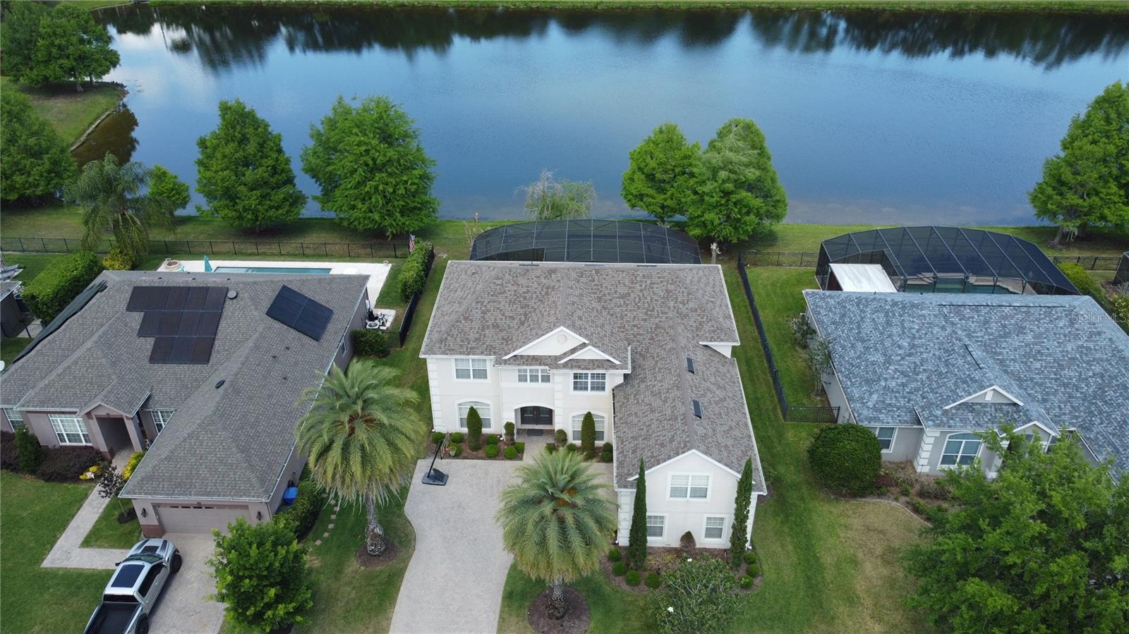 Set within the gated Preserve at Black Hammock, this exceptional pool home offers 4 bedrooms, 4 bathrooms, and a thoughtfully designed layout ideal for multigenerational living and entertaining; featuring two primary suites—one on the main level and one upstairs—along with a dedicated office, expansive upstairs family room, and a large bonus/media room complete with roll-down screen, projector, and receiver, this home seamlessly blends comfort and functionality. The chef’s kitchen showcases quartz countertops, stainless steel appliances, double ovens, an exterior-vented hood, and abundant prep space, all opening to a spacious great room highlighted by a custom stone feature wall and striking electric fireplace, while automatic electric blinds enhance the downstairs primary suite, kitchen, and great room. Step outside to a stunning custom heated pool completed in 2020 with misting system and a panoramic screen enclosure offering unobstructed water views, creating a true backyard retreat; additional highlights include an oversized garage with ample storage, 80-gallon water heater (2021), new roof (2023), and energy-efficient A/C (2017). Ideally located in highly desirable Oviedo with top-rated schools and convenient access to major highways, dining, shopping, Orlando International Airport, downtown Orlando, and Florida’s world-famous beaches and attractions, this home offers the perfect blend of luxury, location, and lifestyle.