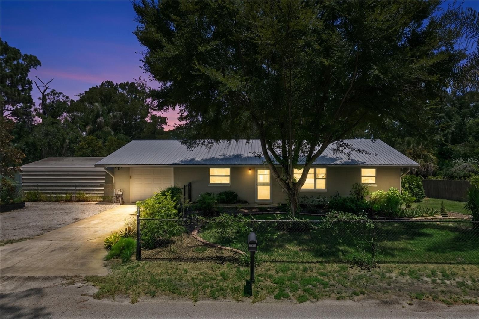 Imagine living surrounded by trees, nature and a small lake behind your house. Now imagine the calmness of country life but close enough to go to the grocery store or grab a coffee. This is the house for you! 3 bedroom split floor plan and 2 baths. Open living/dining room. Beyond is an a/c Florida room. Also an enclosed covered screened in patio with a fireplace for cozy nights. Fenced in front and back yard. Ample parking with a covered metal carport. Beautiful landscape to attract birds and more. Located on a dead end street and is the last house. This is a well kept home waiting for new birdwatchers!