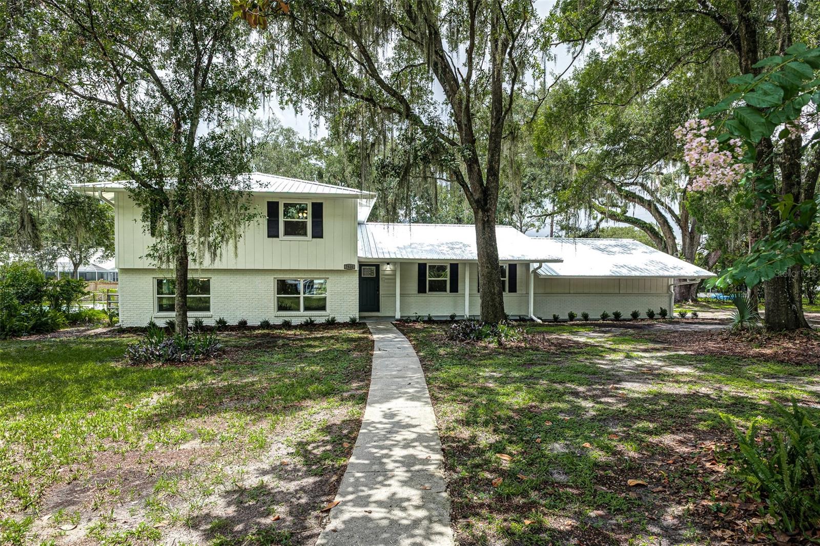 USDA FINANCING AVAILABLE FOR ELIGIBLE BUYERS, WITH NO MONEY DOWN. CALL TODAY FOR MORE DETAILS. Situated on a beautiful one-acre lot in Lakeland with NO HOA, this beautifully updated two-story pool home offers the perfect combination of modern upgrades, generous living space, and the freedom to enjoy your property without community restrictions. Featuring 5 bedrooms, 3 bathrooms, and 2,715 square feet of living space, this move-in ready home has been thoughtfully refreshed from top to bottom.

Step inside to discover brand new luxury vinyl plank flooring throughout, creating a fresh and cohesive feel across the home's spacious layout. Multiple living areas provide flexibility for entertaining or relaxing, while the inviting fireplace adds warmth and character to the main living space.

The completely updated kitchen is designed to impress with brand new cabinetry, beautiful new quartz countertops, brand new appliances, and updated fixtures that give the space a clean, modern finish. Whether you're preparing meals for family or hosting guests, this kitchen is both stylish and functional. All bedrooms have been updated with brand new carpet and ceiling fans.

Comfort is a priority year-round with two brand new A/C systems, new windows, re-piped plumbing, and a new electric water heater. There is also a large interior laundry room for added convenience. The home's five generously sized bedrooms and three full bathrooms provide plenty of room for family and visitors.

Outside, enjoy your own private fenced-in backyard retreat featuring a swimming pool, screened-in rear porch, an outdoor storage shed, and a full acre of land with endless possibilities for recreation, gardening, or simply enjoying the outdoors. A two-car garage provides ample parking and additional storage space.
With extensive updates already completed, modern finishes throughout, and the rare combination of acreage, a pool, and NO HOA, this exceptional Lakeland property is ready for its next owner to move right in and make it home.
