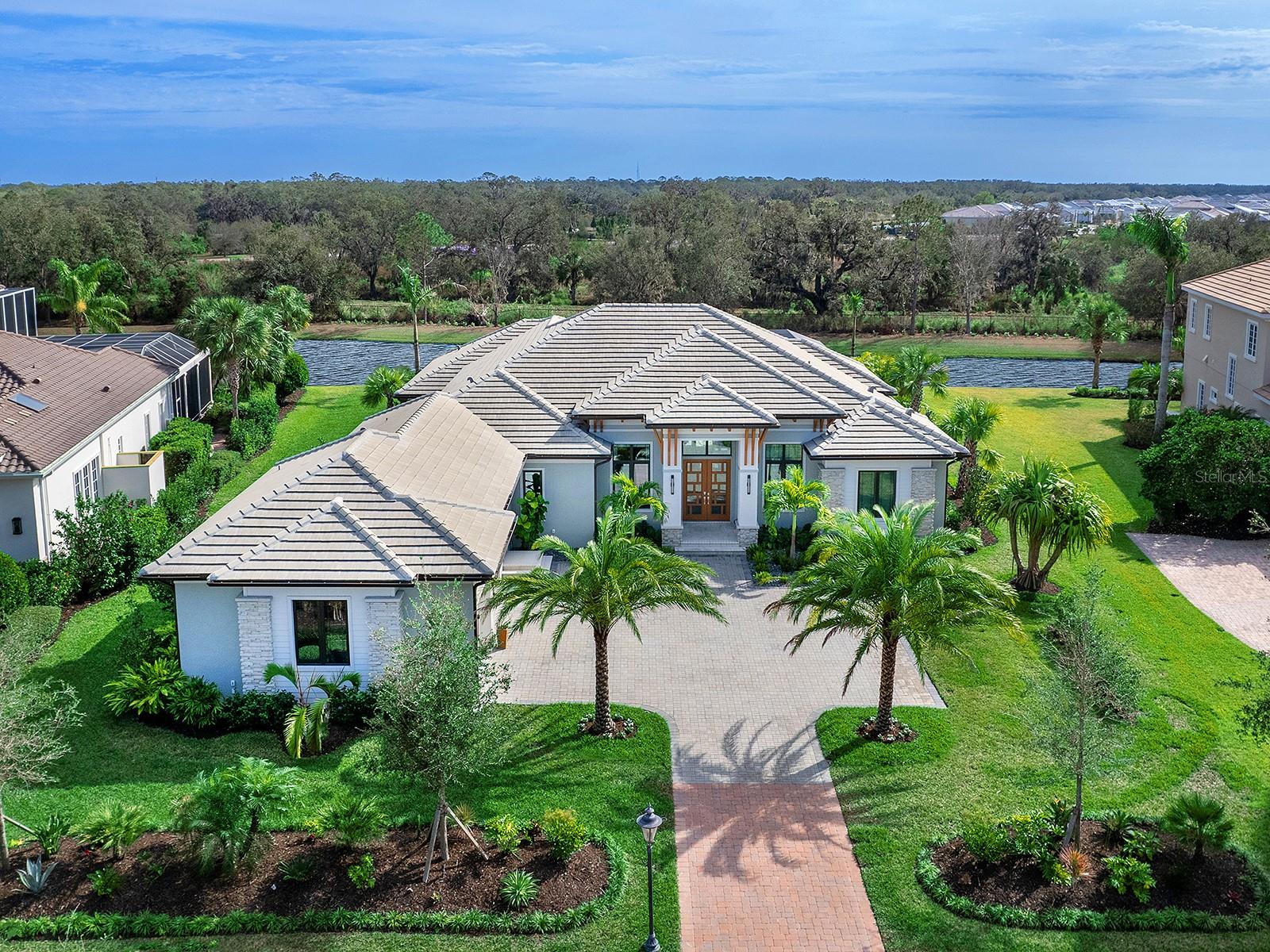 There is only one Founders Club, and there is nothing ordinary about the private, elegant, upscale environment that this 24-hour guard-gated community is known for.  Just 262 homes make up this desirable, exclusive enclave on 762 lush green acres, convenient to all of Lakewood Ranch and Sarasota while remaining quiet and peaceful.  Built in 2023 is this gorgeous 3,507 square foot custom home built by local builder, Lee Wetherington. The ideal combination of thoughtful design, contemporary features and comfortable, expansive living spaces.  The Smoked European White Oak floors flow seamlessly from room to room.  Stunning designer lighting fixtures, custom window and wall treatments, the finest quality finishes and fixtures, recessed lighting, impact windows and solid wood doors are utilized throughout the home.  The creatively designed layout of this very special home takes full advantage of the ample natural light and beautiful outside views, with an open floor plan, large windows and high ceilings.  From the Great Room, sliding glass doors lead to the 2,300 sq. ft. south-facing, screened lanai - a luxury resort onto itself, providing tranquility and relaxation for the homeowners and the perfect party space to entertain guests, with a fully equipped outdoor kitchen, electric heated pool and spill-edge spa.  Both home cooks and professional chefs will appreciate this well thought out kitchen, stainless-steel Bosch appliances, Sub Zero refrigerator, walk-in pantry with solid wood shelving and sleek modern cabinetry.  The kitchen, with its huge window and large format Italian porcelain tile backsplash, opens onto the casual dining space and wine bar area with wine refrigerator and additional cabinetry.  The more formal dining area has a striking chandelier, custom mirrored accent wall and shares the dual-sided glass display cabinets with the kitchen area wine bar creating a convenient pass-through from wine service to dining. Vestibule doors lead to the primary bedroom wing, constructed with mineral wool sound mitigation inside the shared entertaining-area walls for additional soundproofing, as well as floor-to-ceiling windows and a glass door opening to the lanai.  The tailormade “dream” closet, is substantial in size and aesthetically pleasing to the eyes with an upscale closet organization system.  The spa-like master bath has a walk-in frameless shower, oversized soaking tub, separate water closet, makeup vanity, lighted mirrors, Lunada Bay handcrafted tiles and Cambria countertops to round out this indulgent retreat.  There are two beautifully equipped guest suites, each with custom shades, frameless shower enclosures and contemporary lighting fixtures and cabinetry.  Both guest suites open onto the courtyard Zen Garden, the ideal private space for your guests to enjoy morning coffee or an evening cocktail. For added convenience, there is an 89 square foot air-conditioned Florida basement, providing the ideal extra-storage space as well as a full-size refrigerator.  The home is built for secure living, in addition to the impact windows and doors throughout there is a 26kw whole house generator.  This residence provides beauty, privacy, exclusivity, safety and a premier location – the best of Florida living, inside and outside. It is truly one of a kind and only 15 minutes from Downtown Sarasota. Optional memberships are available at the Founders Golf Club offering golf, tennis, fitness, Pilates & yoga, massage therapy and dining.