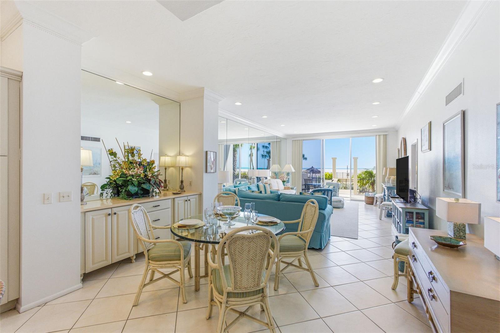 Entertaining any and all offers...the highest ceilings in the building, 10 ft. unusual for a building built in the 70s!  The benefits of owning a first-floor beachfront condo versus a beachfront home. Only one of two beach condos is like this at Lido Beach Club. Owned since 1975.   Only two units in this complex are beachfront on the first floor. There are no lobby or elevator hassles for this unit, these two rest in a PRIVATE wing of the building. The Lido Beach Club condo building has never had any interior flooding. Located next to The Ritz-Carlton Beach Residences and neighboring the new Rosewood Residences (where prices start at 7million)! This first-floor private gulf-front two-bedroom, two-bath Beach home condo is where luxury meets coastal tranquility. This condo offers an unparalleled walkout to your lanai, blending the beach lifestyle with elegance, comfort, and breathtaking waterfront views. Fresh paint hues, high 10-foot ceilings in great rooms and bedrooms, and a massive mirrored wall accentuate the high-end finishes in turquoise, blues, greens, and beige, creating a coastal charm decor. Light dances through the large lanai and master bedroom sliders out to the lower pool deck and beach. From the pillow-tile kitchen backsplash and all-new GE Profile appliances, including a 5-burner cooktop and single oven, #102 is turnkey furnished; check out the inventory list with three newer televisions and a multitude of accessories! If you wish to use this property as a residence or an investment, it embodies a formula of coastal elegance. The Rental of this property has been solid through most of the fall and spring seasons. Henredon and Martha Stewart master bedroom furnishings, a scattering of Annie Selke throw rugs, luxe upholstery, two new full beds and chests in the guest room, and a newly remodeled guest bath captivate the decor. Expansive light-filled sliders in the Living and Master bedroom invite you to enjoy the heated Gulf-front pool with private beach access. Your sizable private porch features dining and two sunbathing chaises, perfect for unwinding, watching a spectacular sunset, or enjoying your morning coffee. LBC features a fitness room with a sauna to support a healthy, fit lifestyle, a community room with a full kitchen adjacent to the main lobby, and a beachfront grilling area. Lido Key Park is not far off, featuring bike trails and a kayaking area through mangroves. On the North side of the key, an Olympic-sized pool and the Lido Key Blue Pavilion complex are located. Next door to LBC is the Ritz-Carlton Beach Club with a beach bar, and it's a mere 1.2 miles to St. Armands Circle's restaurants, boutiques, and cultural events. Lido Beach Club has the Milestone report, on-site management, and secure entry to the building and the beach. This community is more than just a place to live; it's a place to thrive! Here, the beauty of the Gulf of America becomes an extension of your home, and every day is a celebration of effortless coastal luxury.