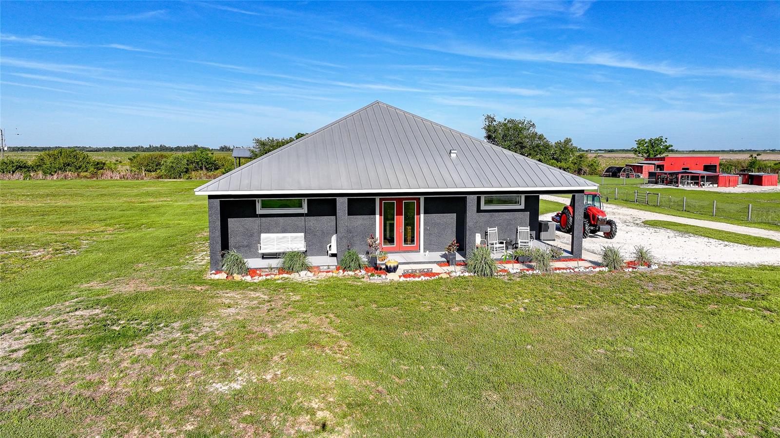 Welcome to the End Of The Road Farm. This is NOT a hobby farm. This is a turn-key, boots-on, coffee-on-the-porch, eggs-before-emails kind of property. Custom built in 2021 and lovingly owned by one owner, this 15-acre homestead is being sold mostly furnished, which means you can arrive with your suitcase and start living the life immediately. Let’s start outside, because the land is doing the absolute most. You’ve got a livestock barn with power, a shipping container with power, A/C, and two generators, a 10x20 greenhouse with irrigation, multiple chicken coops including a brooder, and a well house featuring a whole-farm reverse osmosis system plus an outdoor shower. There’s a massive 24x48 pole barn with RV hookup, the beginnings of a thoughtfully planned food forest with lemongrass, herbs, passion fruit, dragon fruit, and sea grape, a 40x80 irrigated garden, and so much open land it’s currently used as a hay field. Add in a 2-acre pond, underground power, power run throughout the property, and Starlink equipment already in place, and this farm is built for real living, not just dreaming.  Now let’s talk about the house, because it is absolutely the star of the show. The custom home features a gorgeous open floor plan with soaring ceilings that immediately make the space feel grand yet welcoming. The kitchen is a dream come true with hand-selected hickory cabinetry, granite countertops, and a classic farmhouse sink that fits the lifestyle perfectly. Three bedrooms and two bathrooms give everyone room to breathe, and the large utility room makes everyday life actually functional. The primary suite is a true retreat with two walk-in closets and a supersized bathroom featuring a walk-in shower with dual shower heads. It’s the kind of space that makes mornings slower and evenings quieter. Then there’s the backyard oasis. An inground heated pool, beautifully landscaped and surrounded by a large travertine pool deck, gives you a resort-level place to unwind after a long day on the land or to host unforgettable gatherings under the stars. This property isn’t just a home. It’s a vision already brought to life. If you’ve been waiting for a farm that actually works, one that’s beautiful, intentional, and ready on day one, this is it. (There is so much more to love about this property and a full marketing brochure is available upon request.)