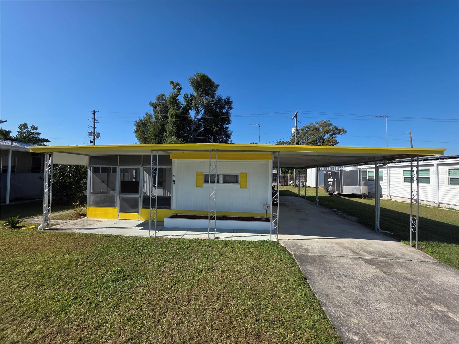 Looking for an affordable seasonal escape in sunny Florida or a budget-friendly permanent home in a vibrant 55+ community? This charming 2-bedroom, 1-bathroom home with additions might be just what you need. A freshly painted exterior offers a cheerful welcome as you arrive, with a long driveway and attached carport perfect for parking or entertaining, plus a covered front walkway leading to a vinyl-enclosed screen porch. Inside, there’s a bonus room accessible from the porch or open to the central living room, which features decorative lighting, laminate floors, and a built-in display hutch, which flows into a spacious eat-in kitchen at the front of the home. Toward the back, you’ll find a full hall bath, an add-on guest bedroom with dual closets and built-in dressers, and a primary bedroom with the same plus a convenient built-in desk for extra storage. An attached utility room offers double doors for golf cart parking, a washer/dryer, plenty of storage, a sink, and a workbench with vice and pegboard. Sold partially furnished with all major appliances included, this home is located in Betmar Acres, one of Florida’s most desirable 55+ communities where you own your land—no lot rent! With annual park dues of just $448, you can enjoy an active lifestyle with amenities like heated pools, hot tubs, golf, pickleball, bingo, and shuffleboard, all in a prime central Florida location close to hospitals, shopping, restaurants, and just an hour from theme parks and award-winning Gulf beaches. Call for more information or schedule your own private tour today!