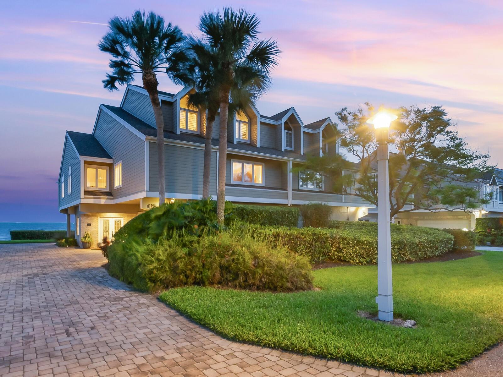 Experience the ultimate in luxury waterfront living in this stunning property located on Tidy Island, a private gated community serenely situated along Sarasota Bay. Totally updated throughout, this bayside gem showcases fabulous views of Longboat Key and Downtown Sarasota while exemplifying the best in quality craftsmanship and attention to detail in the recent interior redesign. The grand entrance welcomes you into a light-filled interior with soaring vaulted ceilings, private elevator and dramatic wood-burning fireplace. Gleaming Brazilian hardwood floors have been installed throughout, along with custom window treatments, upgraded LED lighting and fresh interior paint in every room. With a feeling of comfortable sophistication, the home’s main living areas flow seamlessly providing the perfect backdrop for gracious entertaining, with both a formal Dining area with Chandelier and seating for eight, and an elegant Living Room with fireplace and wide Bay views. Infused with warmth and color, the Family Room features a built-in Bar Cabinet with sustainable cabinetry, wine fridge and Blanco sink. The sleek re-designed European-style Kitchen is sure to please the most discerning homebuyer with the casual Dining Alcove’s plush banquet seating, sustainable Stevenswood cabinetry, built-in appliance garage and convenient Coffee Station. High-end upgrades include black stainless KitchenAid appliances, French door refrigerator and Blanco sink. The primary Bedroom Suite features a new bath with HansGrohe fixtures, CoreTec flooring, make-up vanity and custom closet systems. With a wall of built-in cabinets the Loft area offers a quiet spot for a Den or Home Office but could also serve as a Yoga retreat, exercise studio or additional guest quarters. Head outdoors and enjoy Florida’s beautiful weather on either the Upper Lanai, with its hurricane-resistant glass and stainless steel railing or relax comfortably on the Ground-level Patio which has been transformed to a great spot for entertaining with Italian porcelain tile pavers and fine mesh screen enclosure. A unique low-density enclave of stately waterfront properties, Tidy Island is perfectly positioned amidst manicured grounds and 240 acres of unspoiled preserve and natural shoreline. Resort-style amenities include two sparkling swimming Pools, a residents Clubhouse, Fitness Center, Tennis Courts and miles of walking trails. The community has frequent opportunities for social events and provides full-time Management and maintenance Services as well as a manned Guard Gate. All life’s conveniences can be found surrounding Tidy Island including Dining, shopping, schools and Healthcare. The community is less than an hour’s drive to regional International Airports and locally is within just minutes of the area’s famed Gulf Beaches on Anna Maria Island and Longboat Key.