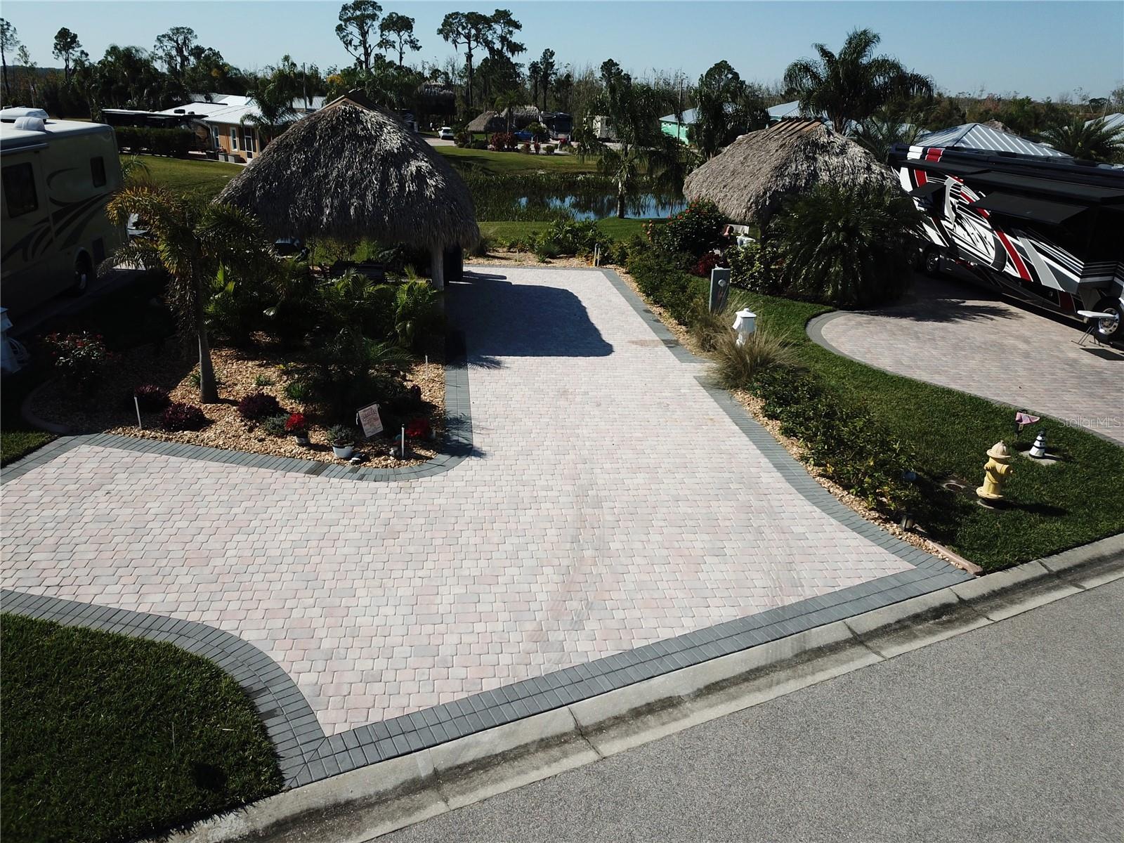 Looking for a vacation spot for your RV in Central Florida? This large paved Pad with a Large Tiki Hut in the gated 55+ community of Bay Lake Motorcoach Resort. Ideal for full-time living, snowbird or investment/rental. It's an easy stroll to the resort's beautiful clubhouse which features a large pool, spa, exercise room, card/game room, banquet room, kitchen, craft and theater rooms. Your large lot can accommodate an excellent Casita if you want to build one in the future. The large Tiki hut is a great place to sit and relax, getting away from the Florida Sun. It's the perfect place to enjoy cookouts. This lot provides a great tropical view of palms and water in the pond with a view of lake Mattie, behind this private lot. The extra sized pavered driveway has ample room to park your Class A or Super C up to 45 ft. motorcoach. RV/Marine lighted pedestal has 50 Amp, 30 Amp, 15 Amp and water connection next to a sewer connection, Don't miss the resort's unique boat dock for private use with a boat launch which provides access into Lake Mattie! Park your MOTORCOACH and relax in luxury. Conveniently located between Tampa and Orlando, this RV Pad offers you great space and a short drive to all central Florida and coastal attractions (20 miles to Disney and all Orlando parks, short distance to nearby airports and surrounding cities), plus golf, restaurants and shopping.