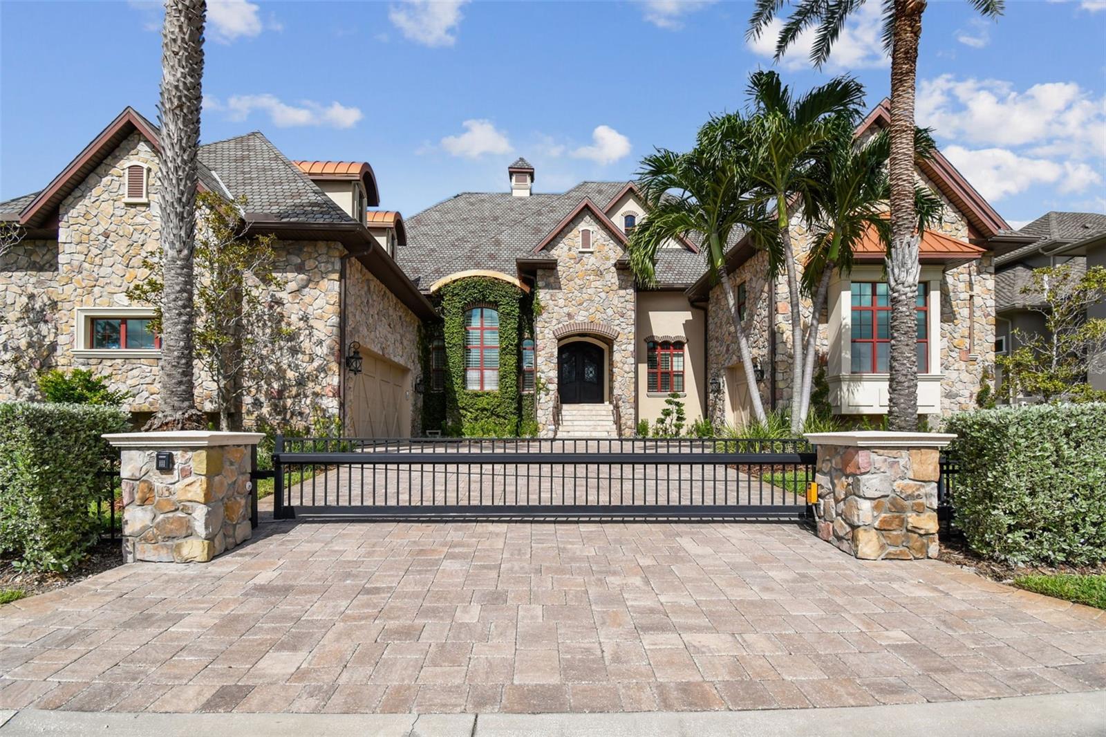 UNIQUE ST. PETE BEACH ELEGANT CUSTOM QUALITY FRENCH STYLE ESTATE, RARE FOR SPB. offering 5 bedrooms, 5.5 baths, and unparalleled craftsmanship throughout. HIGH AND DRY !! Built by a premier custom builder, this residence showcases a dramatic stone facade, expansive open floor plan, and gated private entry creating an estate of distinction. 2025 NEWLY INSTALLED AC UNITS (5 YEAR WARRANTY ATTACHED), NEWLY INSTALLED PRIVATE GATE, NEWLY INSTALLED GARAGE DOOR LOGIC BOARDS.  Step inside to SOARING CEILINGS, exposed hardwood beams, 12" crown molding, 8" baseboards, and finely crafted details that elevate every space. A dramatic entry opens into a BREATHTAKING FOYER with recessed hardwood ceiling and chandelier, leading to both a formal dining room, office space and casual expansive family living space. The GOURMET CHEF'S KITCHEN is a rare true show piece, featuring a LARGE GRANITE CENTER ISLAND with beveled trim, CUSTOME WOOD CABINETRY, soft -close drawers, viking and genAir appliances, culinary center island prep sink, and a LARGE WALK-IN PANTRY. Enjoy the adjacent intimate dining nook with absolutely gorgeous water views. If a formal dining experience is required, retreat to the castle-like formal dining room which will accommodate a large 8-10 comfortable seating arrangement. This Dining room is adjacent to the gourmet kitchen and provides for easy serving but adequate distance. Central living area boasts a double facing indoor-out gas fireplace, dramatic 8' plantation shutters adorn the large hurricane windows that brightly light the living space. Notice the double hardwood french doors that provide access to the incredible balcony and exquisite water views. Our custom textured walls throughout, and arched passageways add architectural elegance throughout this house. Follow these to our double hardwood staircases with iron and wood railings to the second floor. This custom home comes with the space and preparation for the addition of an elevator. The first floor primary suite retreat is complete with dual walk-in closets, spa inspired bathroom, steam room, and a private covered balcony with hardwood ceiling and sweeping water views.  Additional guest/maid/in-law quarters, offer private entry, kitchen, and separate controlled AC on its second floor residency. Outdoor living is equally extraordinary, with lush landscaping, a large saltwater pool and spa. Drive through your private controlled gate to your expansive motor court, additional side resident parking. Enjoy your vine covered stone facade and NEW LUSH LANDSCAPING unique to St. Pete beach. Your private gated back yard is accessed either through hurricane rated French doors or a side vinyl gate. You are immediately engulfed in luxurious new mature landscaping, travertine and grass paver deck surrounding your Pebletec heated saltwater pool and spa. Expansive Dock w/ 20K boat lift, deep water. TWO second floor balconies. . Easy access to Boca Ciega bay and the gulf of America. World class beaches are moments away, This estate offers easy access to many amenities from, yacht clubs, fine dining, shopping, minutes from Tampa International and Clearwater airports, downtown Saint Petersburg, St. Pete beach, museums, theaters, hotels, multiple hospitals, private airport, cigar bars, comedy clubs. The true elegance and custom workmanship of this highly maintained custom home has to be seen to be appreciated. THIS 5213 SQFT CUSTOM ESTATE REMAINED ABSOLUTELY HIGH & DRY, 
SEE THE HARRY POTTER HOME