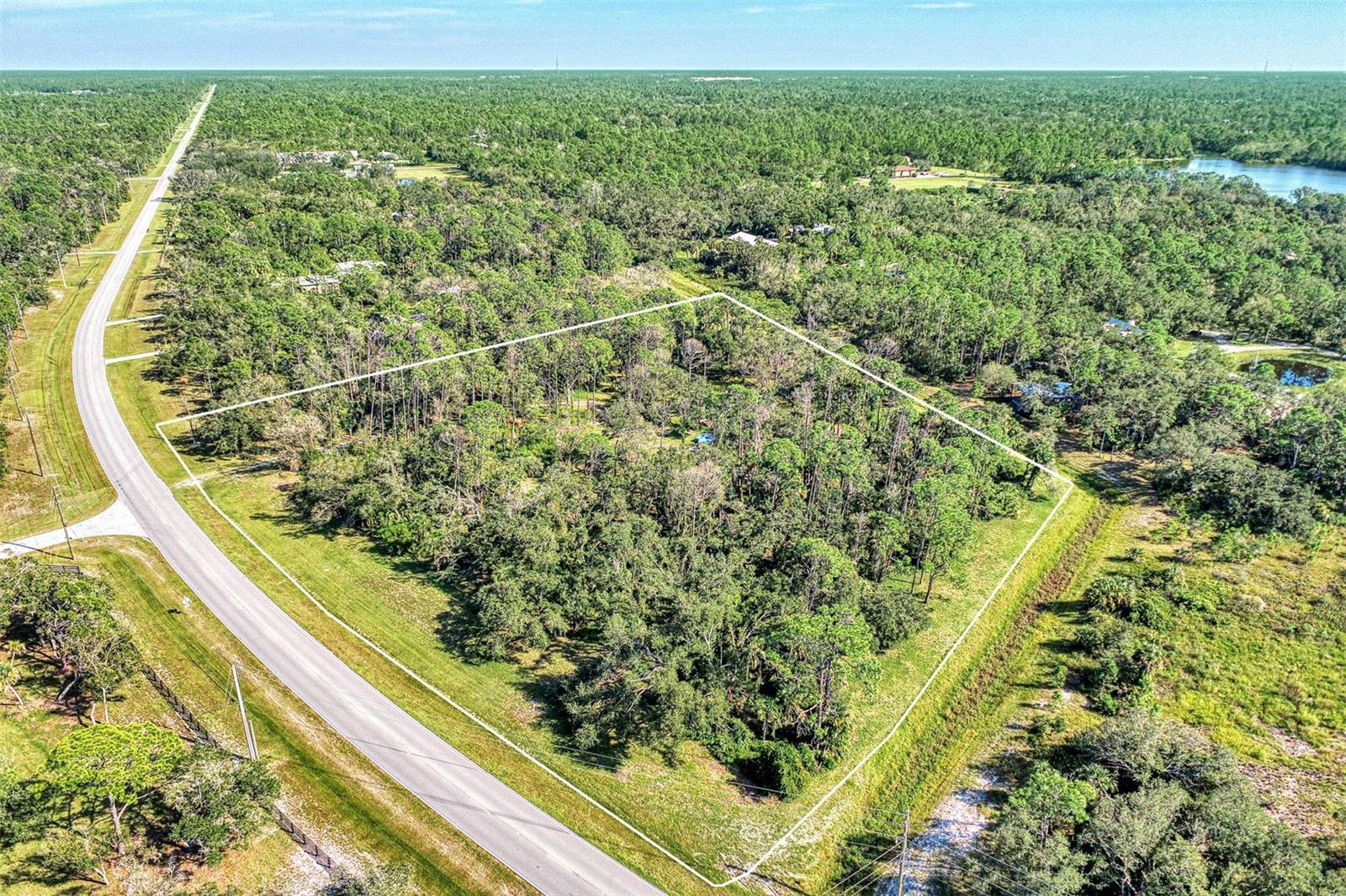 Your North Port Estates Dream Property Awaits! Discover the perfect blend of freedom, privacy, and opportunity with this 4.7-acre property located along scenic Tropicaire Boulevard in sought-after North Port Estates. This impressive parcel offers the ideal canvas to create your dream home and more — whether you envision a custom residence, detached garage, workshop, or even a spacious barn. The front portion of the property has already been cleared, saving you time and expense in preparing for construction. Zoned for agricultural use, this land welcomes horses, farm animals, and endless outdoor possibilities. There’s plenty of room to design a layout that fits your vision — from equestrian facilities to gardens, recreational spaces, or just wide-open green serenity. Nature lovers will appreciate the proximity to Myakkahatchee Creek Environmental Park, just minutes away. Enjoy miles of walking, biking, and horseback riding trails, as well as peaceful natural surroundings where you can unwind and recharge. Despite the quiet country setting, this property is conveniently located close to everything North Port has to offer — shopping, dining, entertainment, and easy access to I-75 are all just a short drive away. You’ll experience the best of both worlds: tranquil rural living with city conveniences nearby. Whether you’re ready to build now or plan for the future, this property presents a rare opportunity to own nearly five acres of usable land in one of North Port’s most desirable locations. Start envisioning your ideal Florida lifestyle — space, nature, and possibility — all right here on Tropicaire Boulevard. This beautiful acreage could be yours!