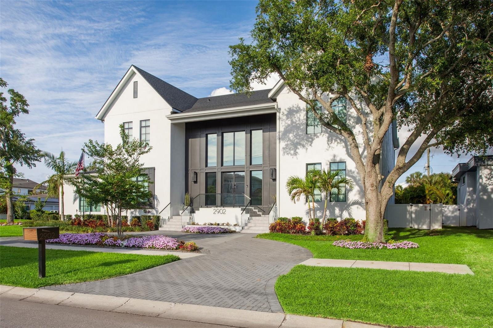 Step into architectural excellence built by Baywalk Custom Homes with this stunning 6,305 sq ft, 5-bedroom, 6-bathroom custom estate, theater room, and a den, ideally situated just under a half-acre in one of the area's most coveted locations in Tampa.
 A grand foyer sets the tone with a dramatic 22-foot foyer ceiling, featuring a dual floating staircase, elevator, and glass railings inside and out that make an unforgettable first impression. Throughout the home, elegant Venetian plaster rooms and accent walls add warmth and texture, seamlessly blending contemporary design with timeless sophistication.
 At the heart of the home is a true culinary dream—a gourmet kitchen complete with dual islands, a hidden walk-in pantry, and a fully equipped chef's kitchen featuring top-of-the-line Thermador appliances, a wine column, two dishwashers, and a built-in coffee maker. It's the perfect space for entertaining or everyday living.
 The soaring 22-foot ceilings continue into the expansive family room, creating a bright, open living space with endless possibilities for hosting or relaxing in style with tons of natural light from the oversized windows.
 Every element of convenience has been considered, from the elevator providing easy access between floors. The downstairs laundry rooms feature a custom dog bath. The home has a mudroom and a Control4 smart home automation system that further enhances daily functionality.  The luxurious master suite is a private retreat, highlighted by a spa-inspired master bathroom with sauna, offering a true escape within your home.  Step outside to your resort-style backyard, with an expansive lanai and outdoor kitchen. This home also includes a pool, sun shelf with in-pool loungers and spa, turf, tropical landscaping, a custom putting green, and hidden roll-down screens on the lanai for seamless indoor-outdoor living. A full-yard automated mosquito system ensures uninterrupted enjoyment year-round.  Car enthusiasts will appreciate the oversized 5-car garage with a lift, perfect for additional storage or showcasing your collection. The home's exterior includes landscape lighting and a Holiday Trim light system; your home will shine with customizable lighting for every holiday or celebration.
 The home is offered furnished.