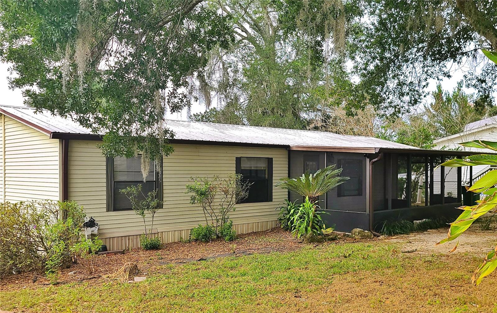 Welcome to this comfortable mobile home situated on a quarter-acre fenced lot. Enjoy the open floor concept when you walk in the front door making it an ideal space for you and your loved ones to stay connected. The primary bedroom has a bathroom with a walk in shower connected for added convenience. All three bedrooms are equipped with walk in closets. Enjoy you coffee, or tea on the screened in front porch and relax with the sounds of nature. The properties expansive outdoor space provides various possibilities and presents an opportunity to own your own piece of land at an affordable price point and conventialy located close to shopping and other amenities.