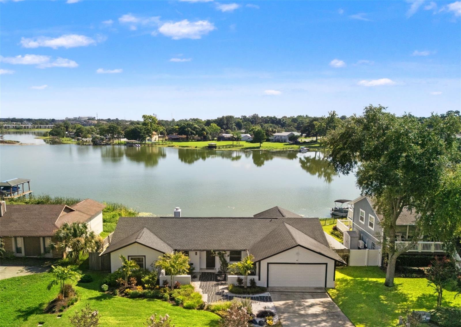 Gorgeous views of Lake Orienta, a 141-acre ski lake. The floor plan offers an open design with functional layout and flow. You enter the home through the courtyard and into the living/dining room with a floor to ceiling brick fireplace. The large fully-equipped kitchen has new soft close cabinets, quartzite counters, new stainless appliances, an island, and a bay window with a breakfast area overlooking the lake. The primary bedroom has nice lake views & sliders to the screened lanai. The split plan includes a den or office, two guest bedrooms, and a new hall bath with a Jacuzzi tub. Other extras include a new wet bar with marine-grade cabinets and beverage cooler on screened lanai, large engineered wood deck, upgraded lighting and Lutron switches throughout, new waterproof laminate flooring & porcelain tile throughout, knockdown ceilings, inside laundry room with utility sink, 2 car garage, 6-panel doors, baths with new vanities & quartzite counters, new ceiling fans, pocket door creating privacy to guest bedrooms. Recent Upgrades include: All New Laminated Impact-Resistant Windows & Sliding Doors, New Landscaping, Low Voltage Lighting, New Irrigation System, New Gutters, New Stormwater Drainage System, New A/C(mini split), New Side Mount Garage Door Motor, New Exterior Paint.  All systems have been well maintained over the years: Roof 2020, AC 2015, electric panel 2017, hot water heater 2012, and re-plumbed 2017. Optional HOA.  You’ll be relaxed whether you are lounging in the sun, out on your boat, paddle-boarding, or enjoying your favorite drink on your screened lanai or deck overlooking the lake. The home is minutes from everywhere, Downtown Winter Park and Downtown Altamonte. You are close to I4, Uptown Altamonte, a myriad of delicious dining experiences, hospital, Winter Park boutique shopping, the Altamonte Mall, movie theaters, and so much more! Don't miss your opportunity to own this amazing home.  Schedule your private showing today!