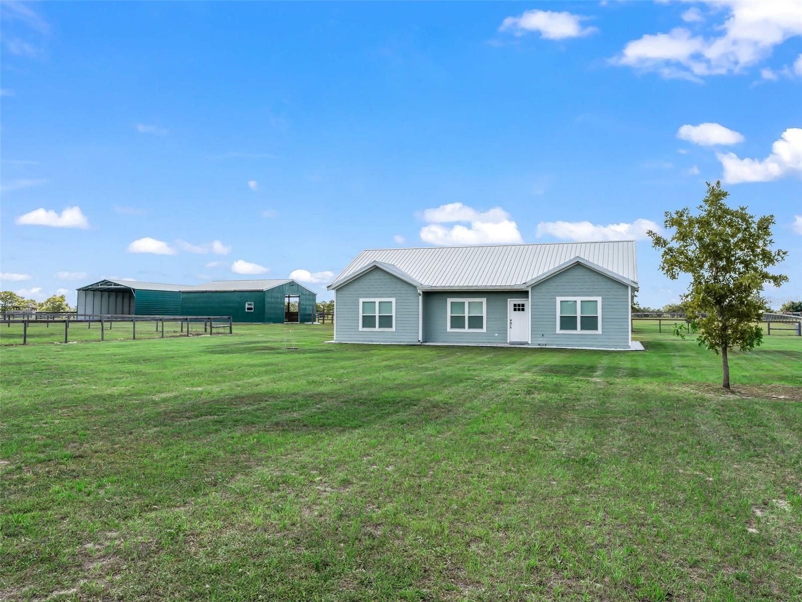Welcome to Steeplechase Farms—an equestrian community with direct access to the 53,000-acre Goethe State Forest and its miles of scenic riding and driving trails. Conveniently located near Black Prong Equestrian Village, this move-in-ready 3BR/2BA home is the perfect retreat for horse enthusiasts. Situated on 5 high and dry acres, the property offers peace of mind with no HOA restrictions. A whole-house Generac generator powered by a 250-gallon propane tank ensures uninterrupted comfort during power outages. Designed with both horses and owners in mind, the property features secure top-board no-climb fencing, an electric front gate, and a spacious three-stall barn with storage and an enclosed tack room. The barn is open and airy with excellent airflow, featuring doors on both the front and back of each stall to allow horses the freedom to move in and out comfortably. A 30’x 60'storage building provides ample space for your horse trailer, camper, and equipment, while the attached 3-car carport adds extra convenience and protection for vehicles. Inside, you’ll find high ceilings, recessed lighting, granite countertops, custom blinds and modern appliances. Relax on the large 384 sq. ft. screened porch overlooking your pastures and horses. Don't miss out on this unique 5 acre Farm where you can enjoy the freedom to ride directly from your property onto miles of beautiful trails.