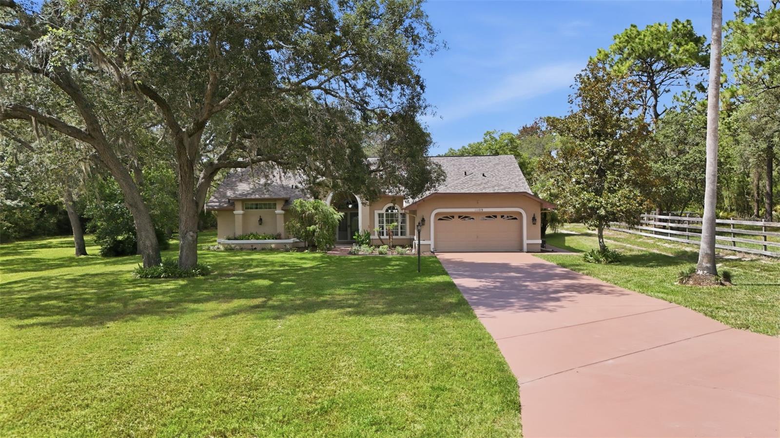 Come see this meticulously maintained 3 bedroom, 2 bath home with a dedicated office, sparkling pool, 2 car garage, and large detached garage/workshop. Situated on a spacious 0.78 acre lot on a quiet dead-end street, the home is located in the deed-restricted Woodland Waters subdivision with low HOA fees. As you enter the home, you’re greeted by a spacious formal living room featuring 3-panel pocket sliding glass doors with unobstructed views of the pool. The primary bedroom also offers private pocket sliders to the pool area, along with his-and-hers walk-in closets and a modern primary bathroom with walk-in shower. The home is built around a fully remodeled kitchen with beautiful granite countertops, offering easy access to the dinette, formal dining area, and living room. The living room boasts high cathedral ceilings and a cozy wood-burning fireplace. Two additional bedrooms and a second bathroom are conveniently located down the hall. The pool is accessible from both an additional bedroom and bathroom for added convenience. Just past the pool you’ll find a shaded outdoor seating area pre-wired for a future hot tub and prewiring on covered patio for outdoor kitchen. Continuing down the sidewalk is the impressive 1,080 sq ft detached garage/workshop. Perfect for a motorcycle, classic car, or all your hobbies. The beautifully landscaped yard is shaded by mature oak trees and tall viburnum bushes that provide excellent privacy. The property butts up to a partially wooded 10-acre parcel, giving you even more space from your neighbors and the feeling that you’ve escaped the subdivision. Both the home and detached garage received BRAND NEW ROOFS in 2025. This well-cared-for home shows true pride of ownership in every detail. Tucked just off US 19, you’re only minutes from multiple shopping/dining options, the Weeki Wachee State Park and their famous crystal-clear freshwater springs. Call today for a private showing!