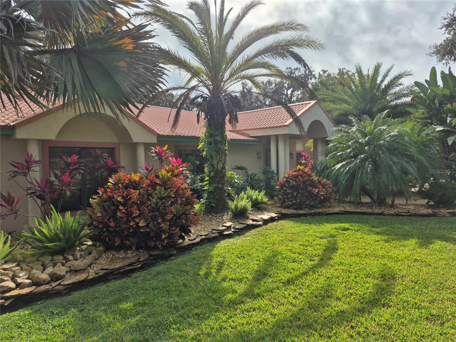 Welcome to your lakefront retreat designed for those who love to host, relax, and live life in style. Nestled on 1.66 acres along the shores of Lake Harris, part of Florida’s highly sought-after Chain of Lakes, this 4,420+ sq ft, 5-bedroom, 4-bath home exudes classic Florida charm. It provides comfort, thoughtful updates, and exceptional outdoor amenities for a resort-style estate.

Enjoy 150 feet of direct waterfront with your private boathouse featuring a 418 sqft, upper-level guest apartment and balcony overlooking the lake, perfect for friends or weekend visitors. Spend your days boating, fishing, or exploring miles of scenic waterways, then unwind poolside or enjoy a twilight match on your private lighted tennis court.

The outdoor experience is truly resort-caliber, highlighted by a sparkling pool surrounded by an entertainment deck and $90,000 in professional landscaping and lighting enhancements that elevate the property’s beauty day and night. Mature oaks, manicured grounds, and custom illumination create a warm, inviting ambiance ideal for gatherings and peaceful evenings by the water.

Inside, the home exudes comfort and relaxation. The formal living area features a beautifully renovated stone fireplace, thoughtfully transformed from its original brick design to create a timeless focal point.

The heart of the home, a spacious entertainer’s kitchen is perfectly designed for dinner parties and gatherings, with generous counter space, dual islands, quartz countertops, modern appliances, a large walk-in pantry and a seamless open layout connecting to multiple living and dining areas, this kitchen makes entertaining effortless and functional.

With 5 bedrooms and 4 full baths, the home offers flexibility for family and guests. The primary bedroom is expansive with a large L-shaped walk-closet.  Additional spaces include formal and casual living areas, a home office, and a flex room. The three-car garage provides abundant space for vehicles and storage. Located on a quiet dead-end street, the property offers privacy and tranquility while remaining just minutes from shopping, dining, and entertainment.

Recent upgrades within the last five years include: $90,000 in Landscaping and lighting, two new HVAC systems, replaced well and sprinkler pumps, a well water treatment system, new outdoor privacy fence, rescreened pool deck, new hot water heaters in both the main home and boathouse, new boathouse roof with portable A/C, metal roof maintenance on the main home (screws and boots replaced), and fresh interior paint in multiple rooms. The kitchen has been extensively updated with a new refrigerator, dual oven, stovetop, sink, faucets, island countertop, and cabinet hardware—plus numerous additional improvements enhancing comfort, efficiency, and style.

Live the ultimate Florida lifestyle—launch your boat from your private dock, take a refreshing swim, or host unforgettable gatherings under the stars. Nearby attractions include Mission Inn Resort & Club (championship golf, spa, and dining), Yalaha German Bakery & Beer Garden (a local favorite for brunch and live music), Lakeridge Winery (Central Florida’s premier vineyard and festival destination), Venetian Gardens Park (waterfront trails, marina, and community events), and The Villages, offering world-class shopping, dining, and nightly entertainment.

Conveniently located minutes from the Florida Turnpike and 441, to all major attractions, and Orlando Airport(MCO)