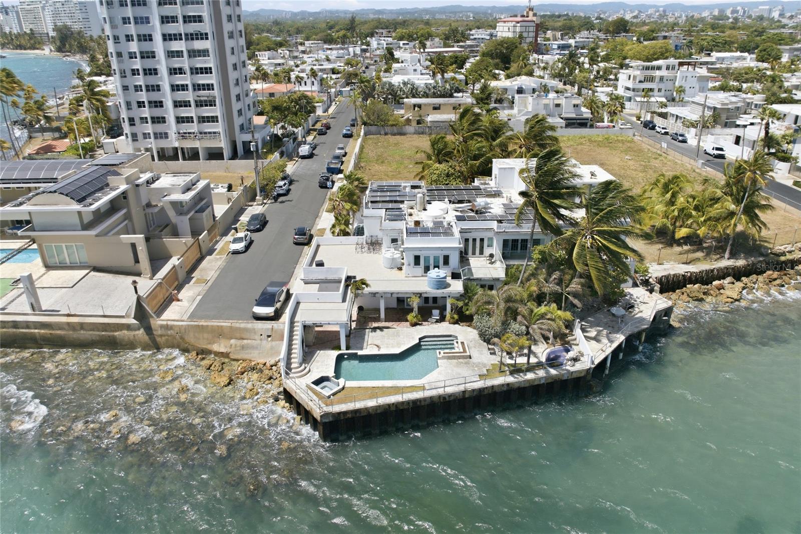 Rare direct beachfront estate at Emajagua Court Condominium in San Juan. Located in a gated community and zoned RT-3 Residential Touristic, this two-level residence combines Units A and B and offers approximately 4,994 sq. ft. of living area, six bedrooms, six full baths plus one half bath, and a two-car garage.

Enjoy panoramic ocean views, direct access to the sand, a swimming pool, whirlpool, open and covered terraces, balconies, patio areas, and space for outdoor living and entertaining. The property includes central A/C, water cisterns, generator, storage, and a paid-off photovoltaic solar system.

The home requires repairs, maintenance, and updating. Buyers should inspect the property and independently verify condition, measurements, permits, zoning and permitted uses, condominium information, solar-system details, and all features. An opportunity to restore and customize a substantial beachfront residence in Ocean Park.