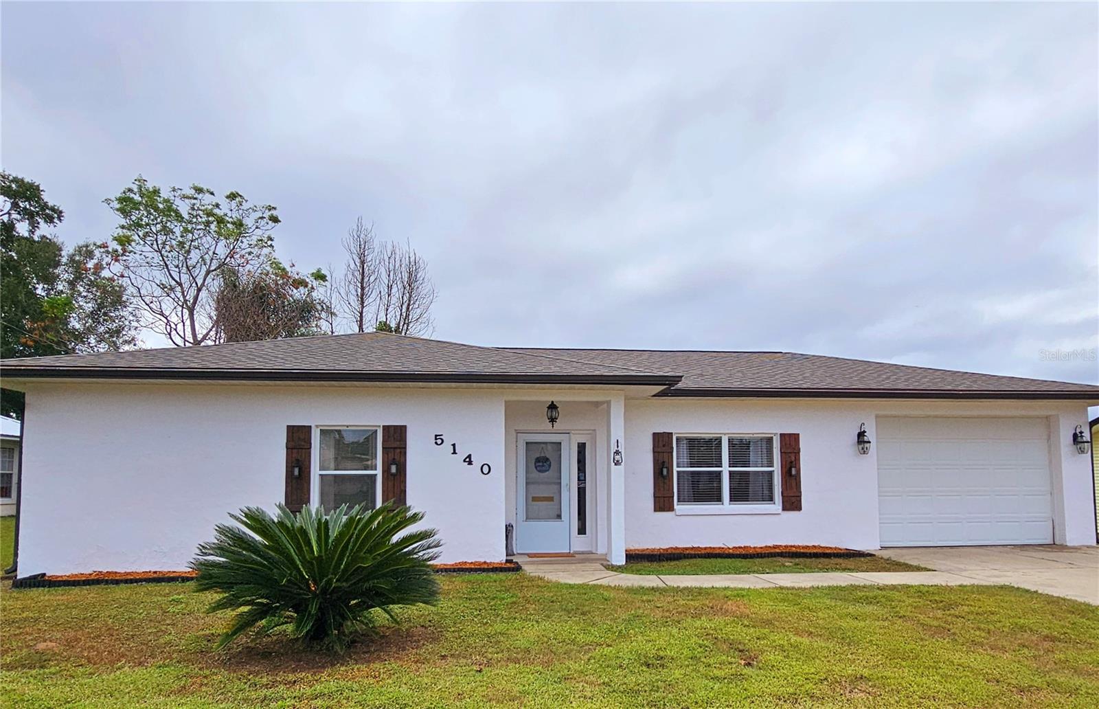 Adorable home! The perfect size home just in time for the new year!! This home offers a nice floor plan with high ceilings, large living room area, beautiful kitchen with coffee bar setup plus plenty of cabinets for storage, nice size primary and guest bedroom as well as large bathroom with a jack & jill type setup, large walk-in closet.  Home has nice back porch to enjoy those morning coffee's or those relaxing evenings for happy hour times.  Lots of space in the back yard for privacy with fencing on several sides could easily be finished off to be completely fenced for complete privacy. Newly painted, updated cabinets, roof 2022 & hot water heater 2021.  Great home for your Florida winter home, 1st time home or investment property. Home located in a great community with no HOA fee's and convenient to Belleview for your everyday needs.