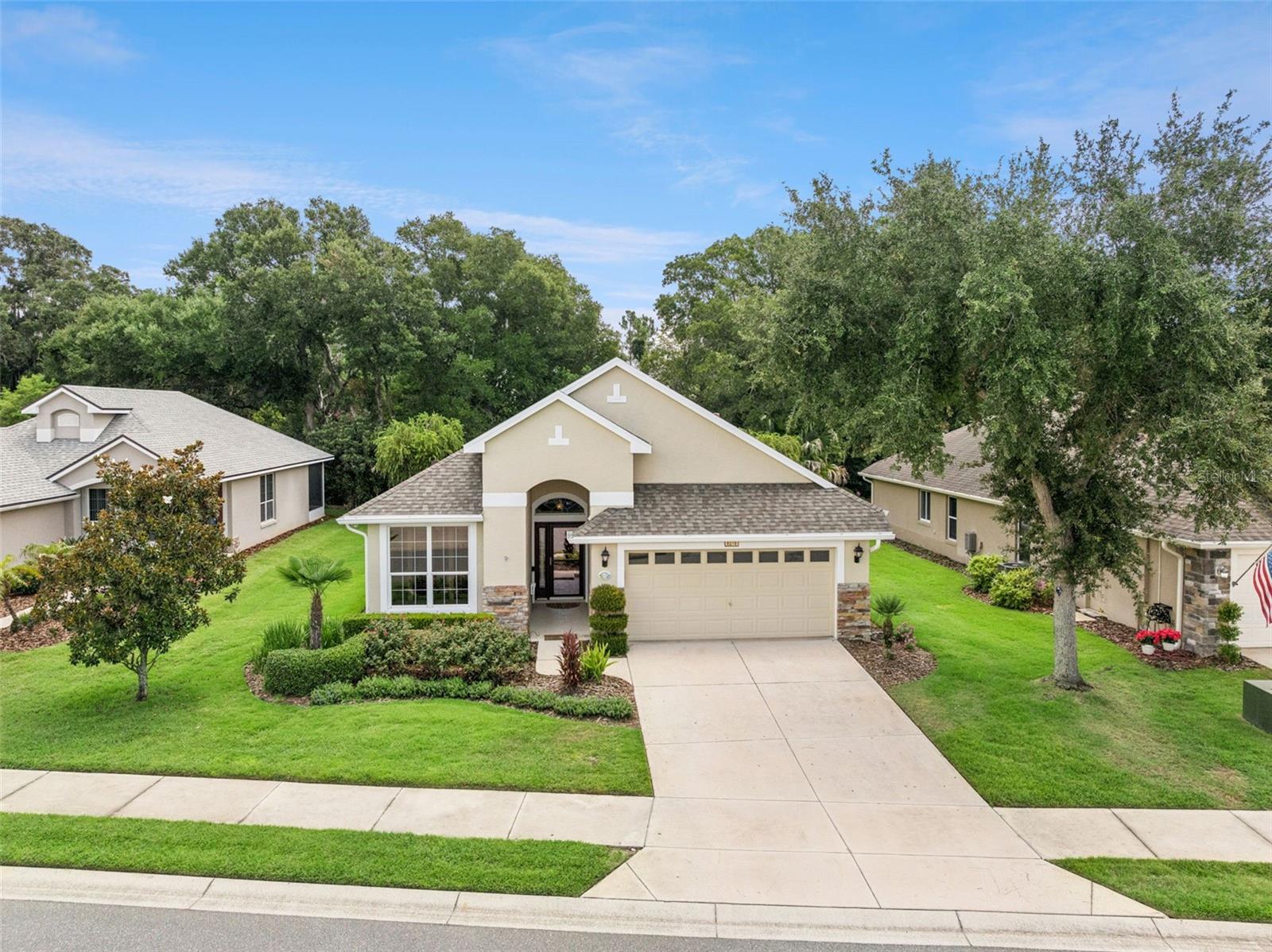 Welcome to your own private retreat in the highly sought-after Lakes of Mount Dora, where every day feels like a vacation.
Nestled on a peaceful homesite overlooking a beautiful wooded back yard, this impeccably maintained 3-bedroom, 2-bath home offers the perfect blend of comfort, privacy, and carefree Florida living. Imagine beginning each morning with a cup of coffee on your screened lanai as birds sing in the trees and nature provides the perfect backdrop for your day. It’s the kind of peaceful setting you’ll never tire of coming home to. Designed with both everyday living and entertaining in mind, this thoughtfully cared-for home features a versatile third bedroom with elegant French doors—perfect as a guest room, home office, library, or hobby space. Every detail reflects the pride of ownership and meticulous maintenance that make this home truly move-in ready. Recent improvements provide exceptional peace of mind, including a brand-new roof and gutters (2026), new furnace (2025) with a transferable warranty, new air conditioning system (2020), freshly painted interior completed less than a month ago, and exterior paint completed just two years ago. Even better, all appliances convey, allowing you to settle in and immediately begin enjoying your new lifestyle. Did we mention the WHOLE HOUSE GENERATOR? Beyond your front door awaits one of Central Florida’s most desirable active adult communities. Lakes of Mount Dora is renowned for its resort-inspired amenities and vibrant social atmosphere. Spend your days enjoying tennis, pickleball, croquet, bocce ball, billiards, darts, a well-equipped fitness center, library, scenic walking trails, and a spectacular resort-style swimming pool with a relaxing hot tub. Paddle a kayak or canoe across the community lakes, cruise in an electric motorboat, or simply enjoy the breathtaking waterfront scenery throughout the neighborhood. Golf enthusiasts will appreciate the convenient golf cart access to the neighboring Mount Dora Country Club with membership, making it easy to enjoy a round of golf or dinner with friends. Homeowners also enjoy the rare convenience of complimentary fenced RV and boat storage, while internet, cable television, and irrigation water are all included in the HOA, adding tremendous value and simplifying everyday living.